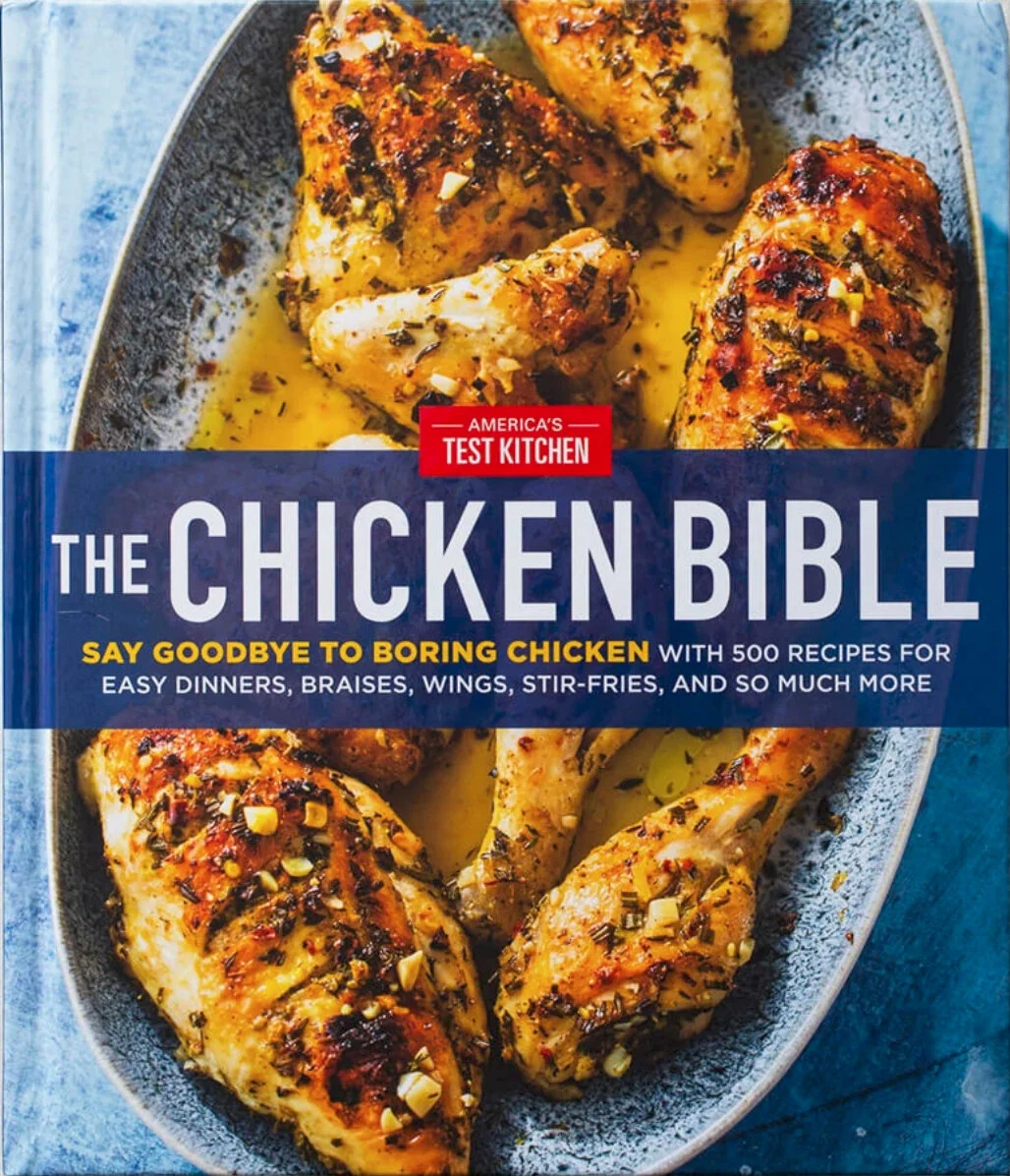 Cookbook cover titled "The Chicken Bible" with a picture of cooked, seasoned chicken drumsticks in a skillet.