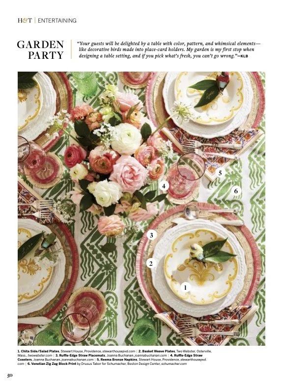 A garden party table setting with colorful plates, floral centerpiece, pink drinks, and decorative napkins.