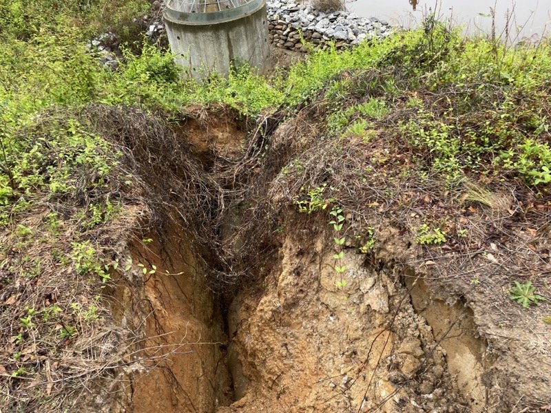 This large sinkhole formed around a retention pond riser due to a pipe separation.