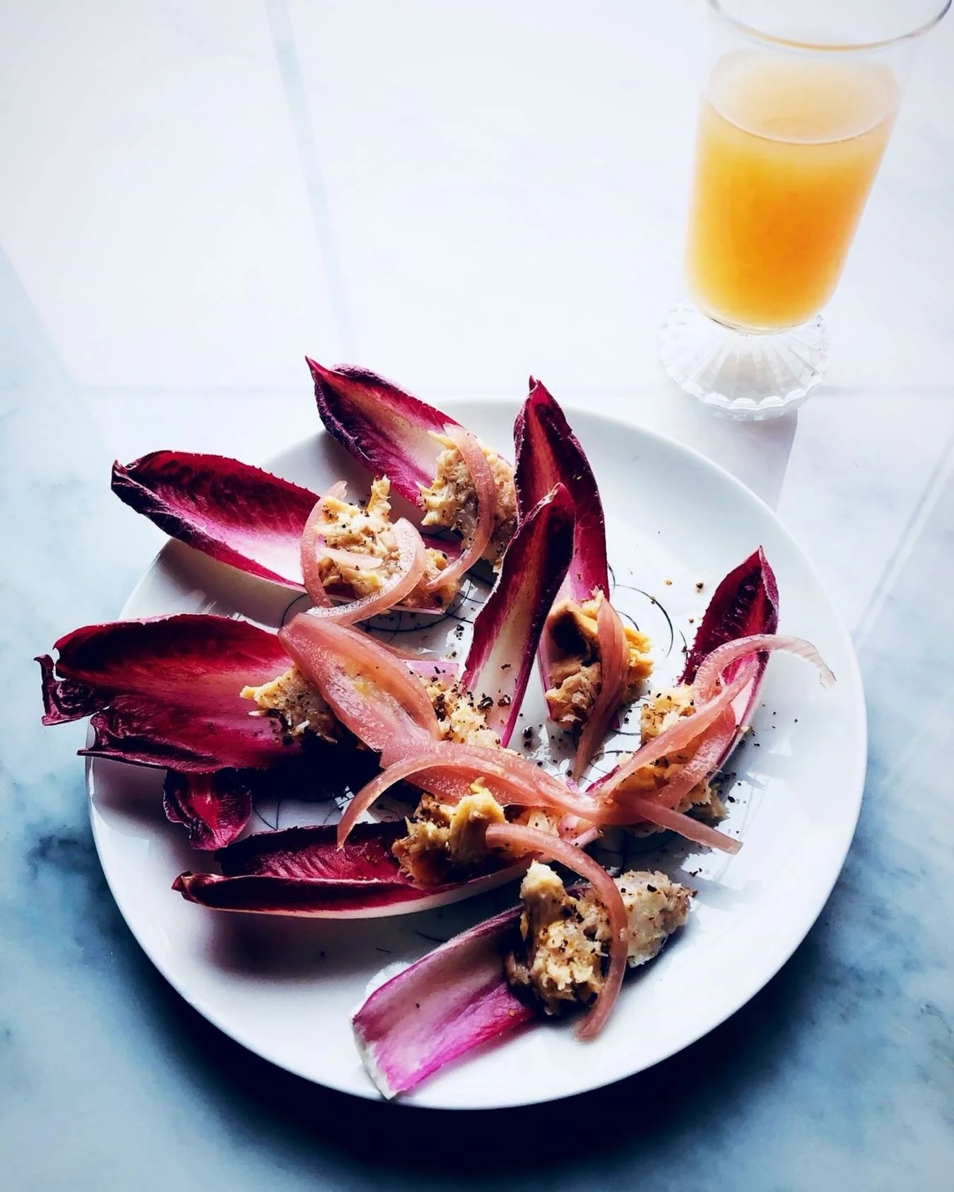 Simple snack idea for eating during the Oscar&rsquo;s .
Smear endive with a little labne or sour cream mixed with a little horseradish add Smoked trout and pickled onion - yum add trout eggs for a little pop ! Black pepper . Let the awards begin ! My