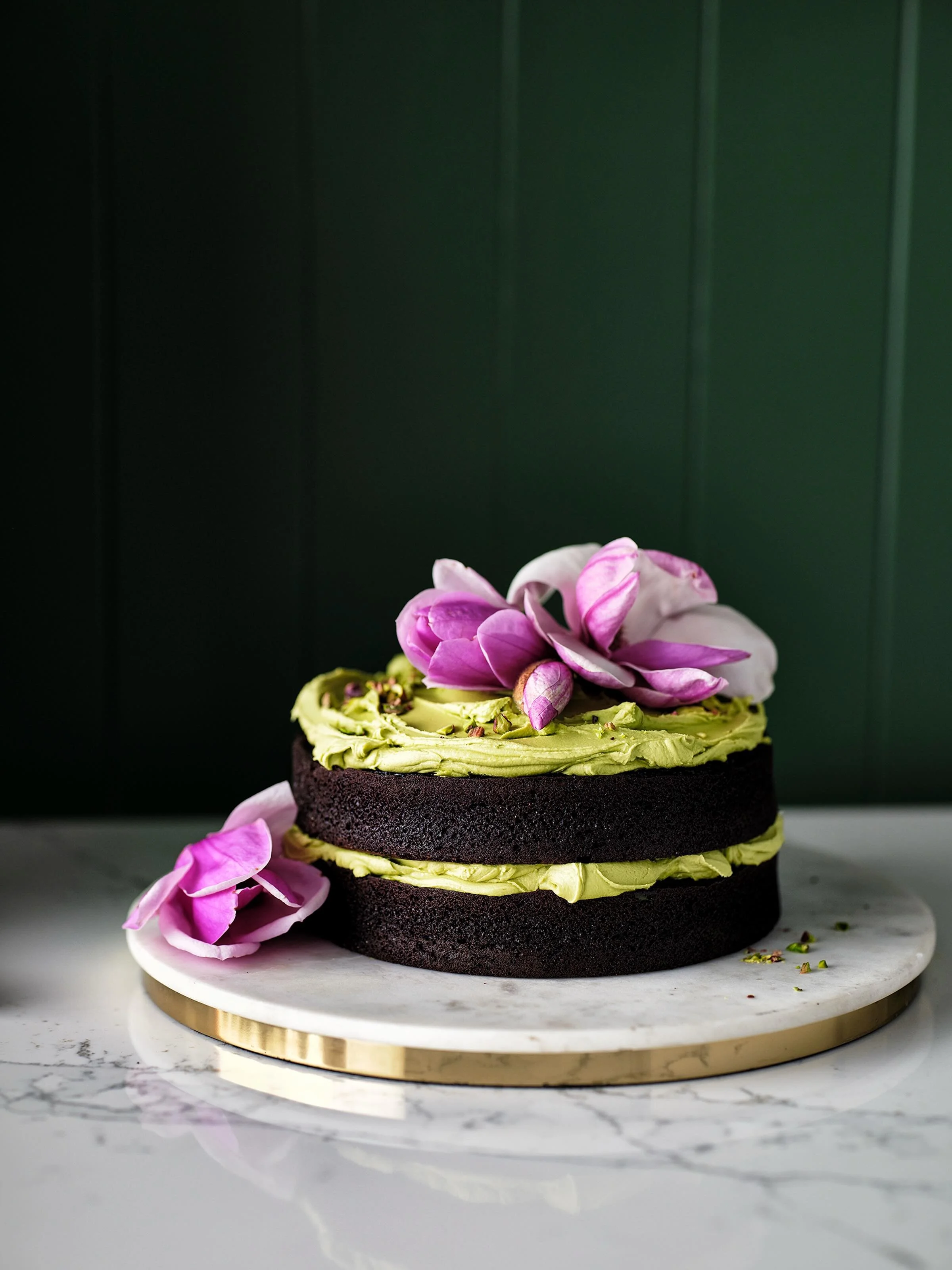 Magnolia, chocolate and pistachio cake that didn&rsquo;t make the cut ! From back in January .. 📷 @chriscourt prop styling @elkiestylist . I loved foraging the magnolias but flowers on food are often left out of the edit #chocolatecake #magnolia