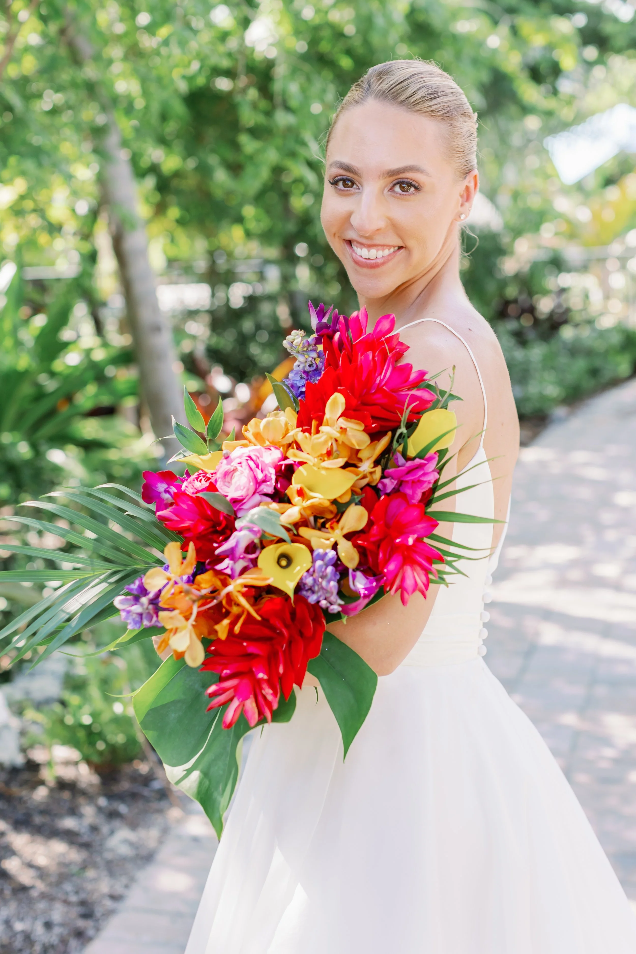 Bride holding a colorful bouquet of flowers outdoors