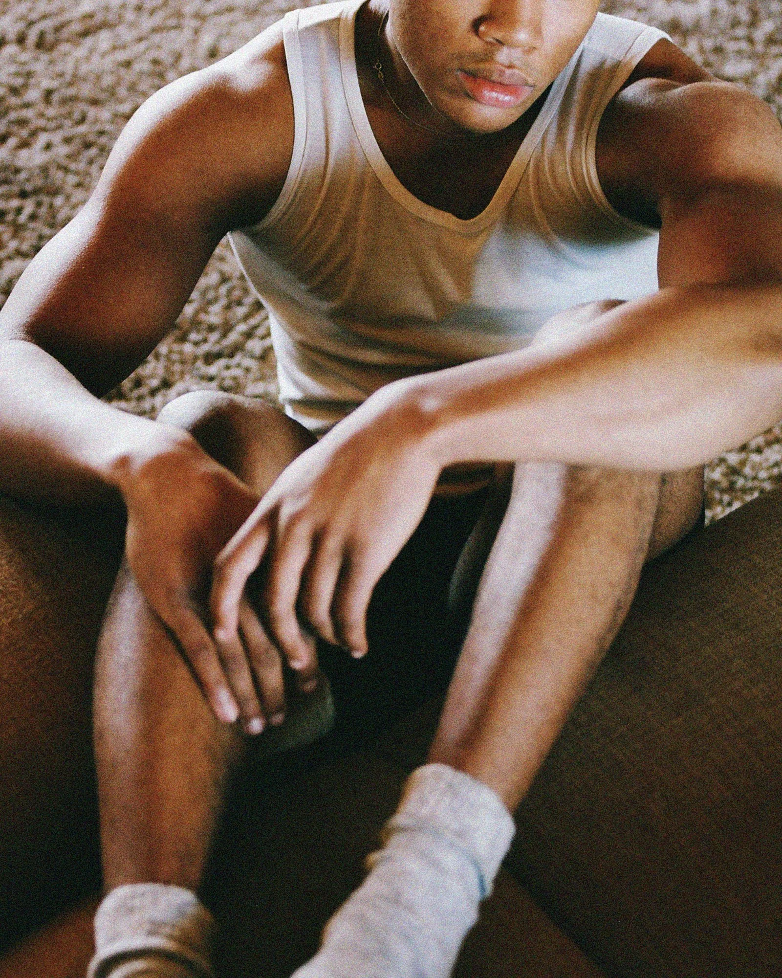 Close-up of a person in athletic wear, possibly during exercise, with hands and arms extended forward.