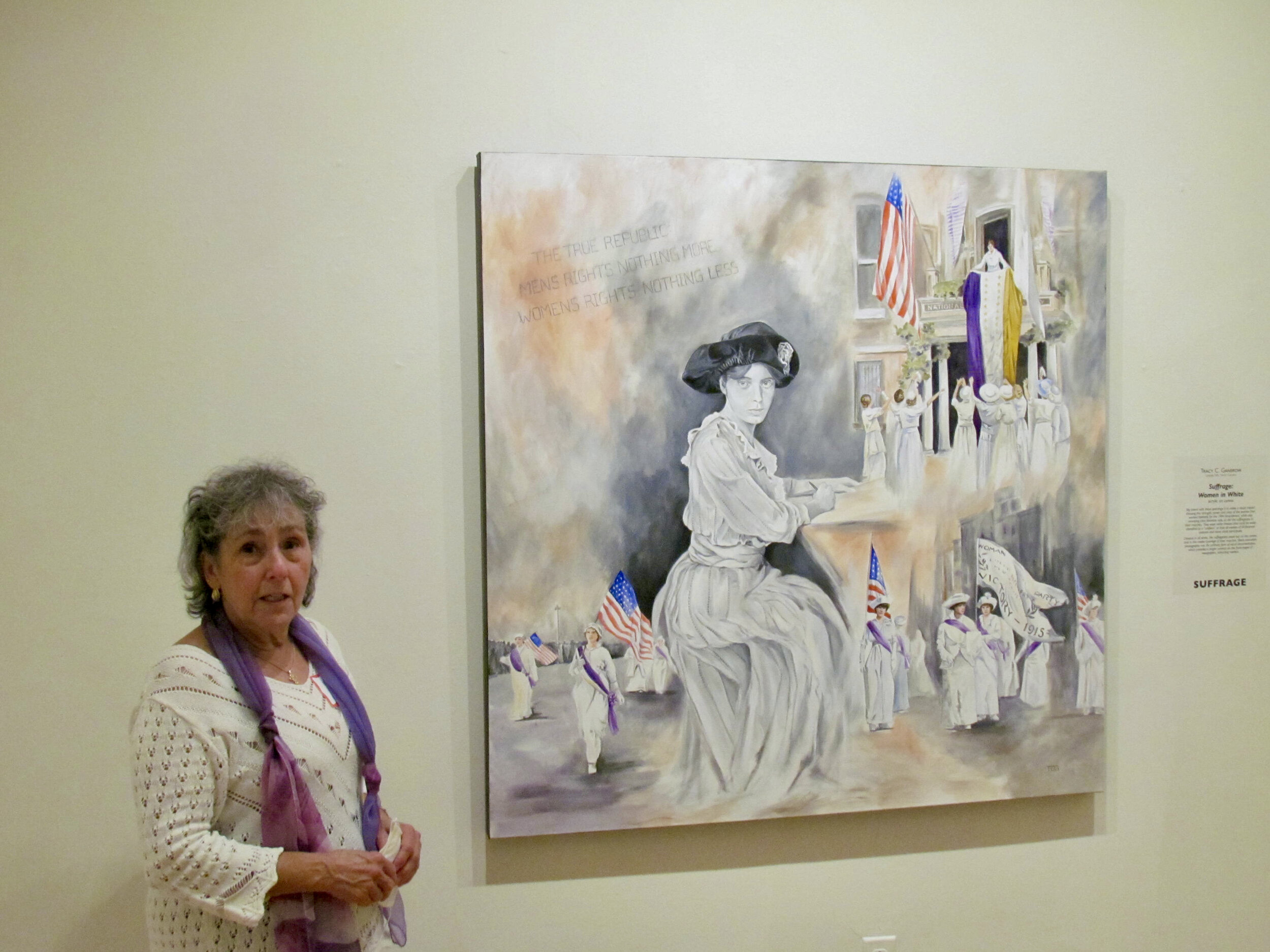 Barbara Servino standing beside "Suffrage:  Women in White."