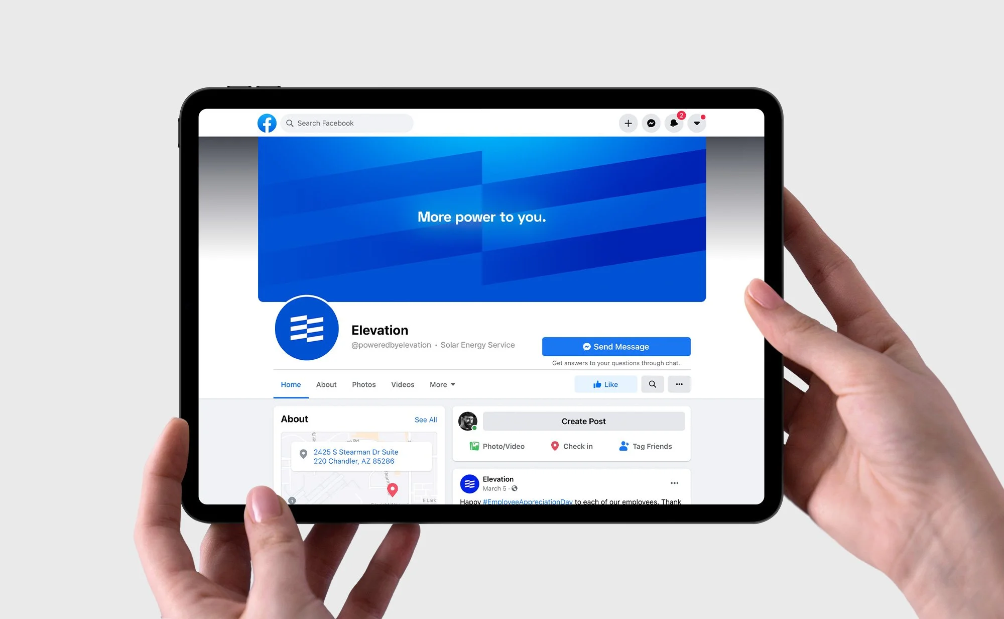 Person holding a tablet displaying a solar energy service Facebook page with a blue banner that says "More power to you."