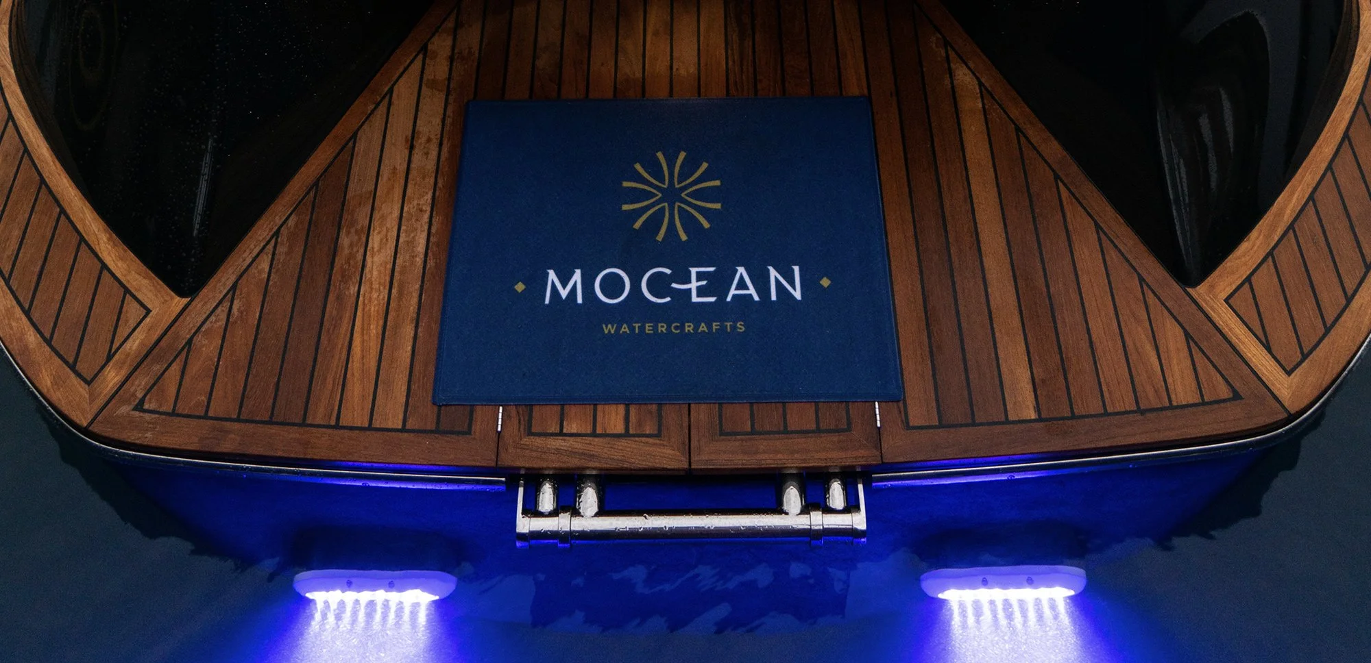 Boat stern platform with wooden finish and "Mocean Watercrafts" mat.