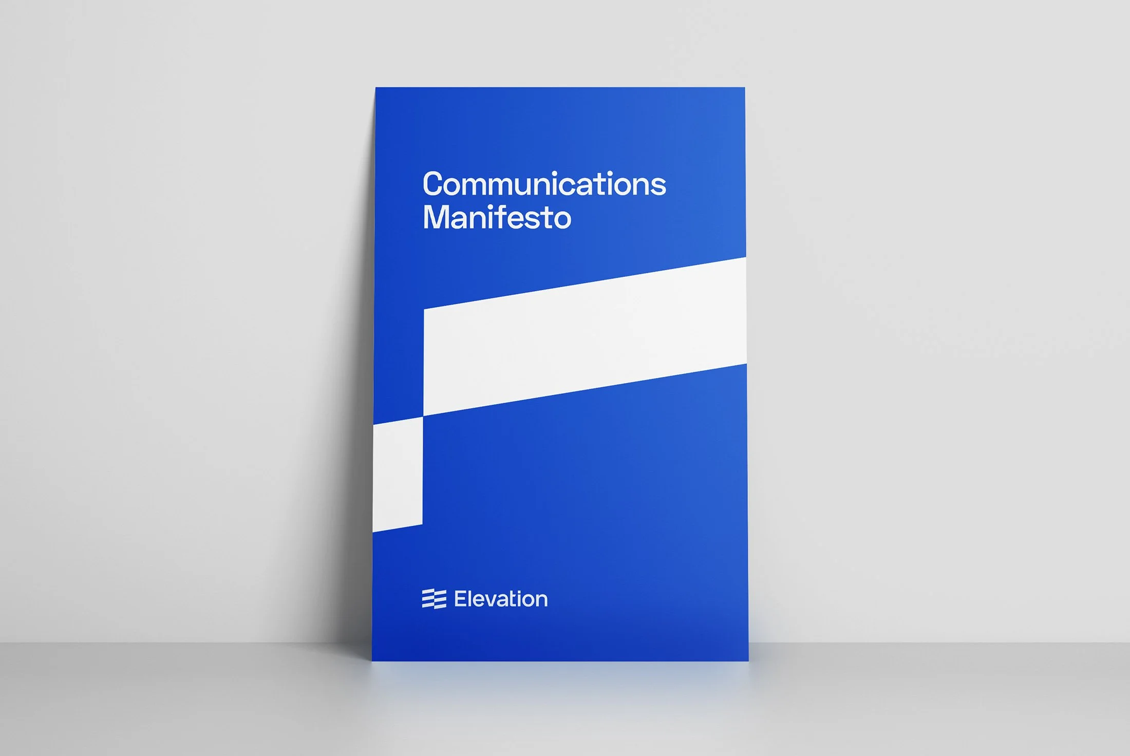 Blue book titled "Communications Manifesto" on a white surface.