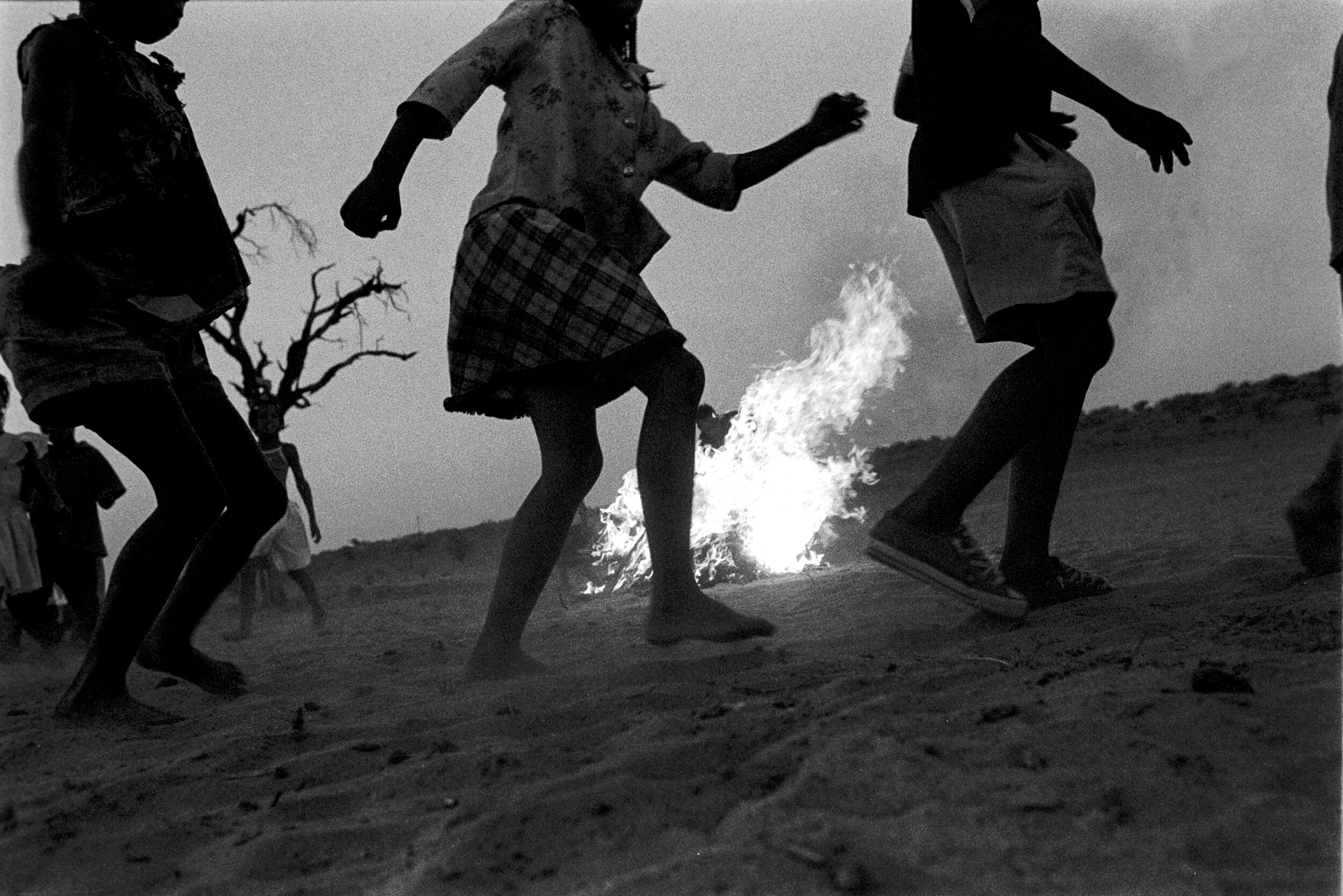  Children dancing around a fire, part of a story on four of the last remaining seven !Nu speakers, near Askham, Molopo. Northern Kalahari. 2 October 2003. (c) Leonie Marinovich. 