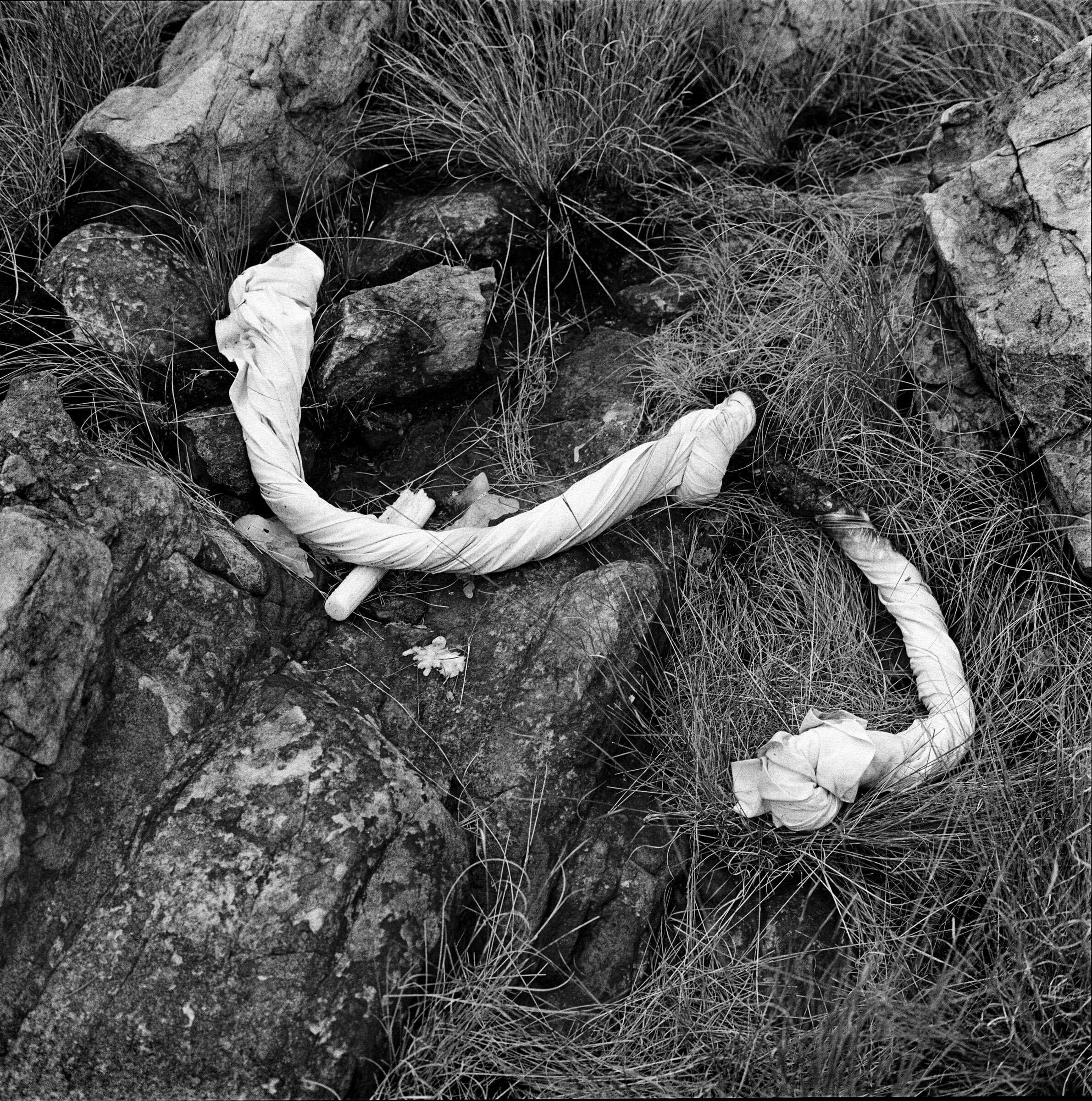 A candle and a twisted, knotted and charred cotton cloth remain on the high rocks of Melville Koppies in Johannesburg, South Africa., after a night ritual by members of a Zioni church sect, 2007.  photo Greg Marinovich 