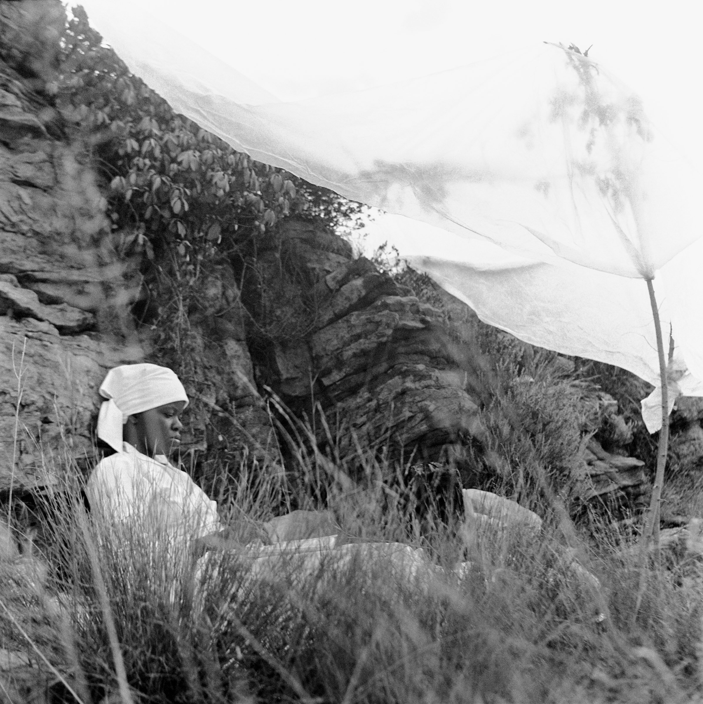  A female member of a Zioni sect reads a bible under a shelter of plastic sheet alongside rocks on Melville Koppie, Johannesburg, South Africa, 2007. photo Greg Marinovich 