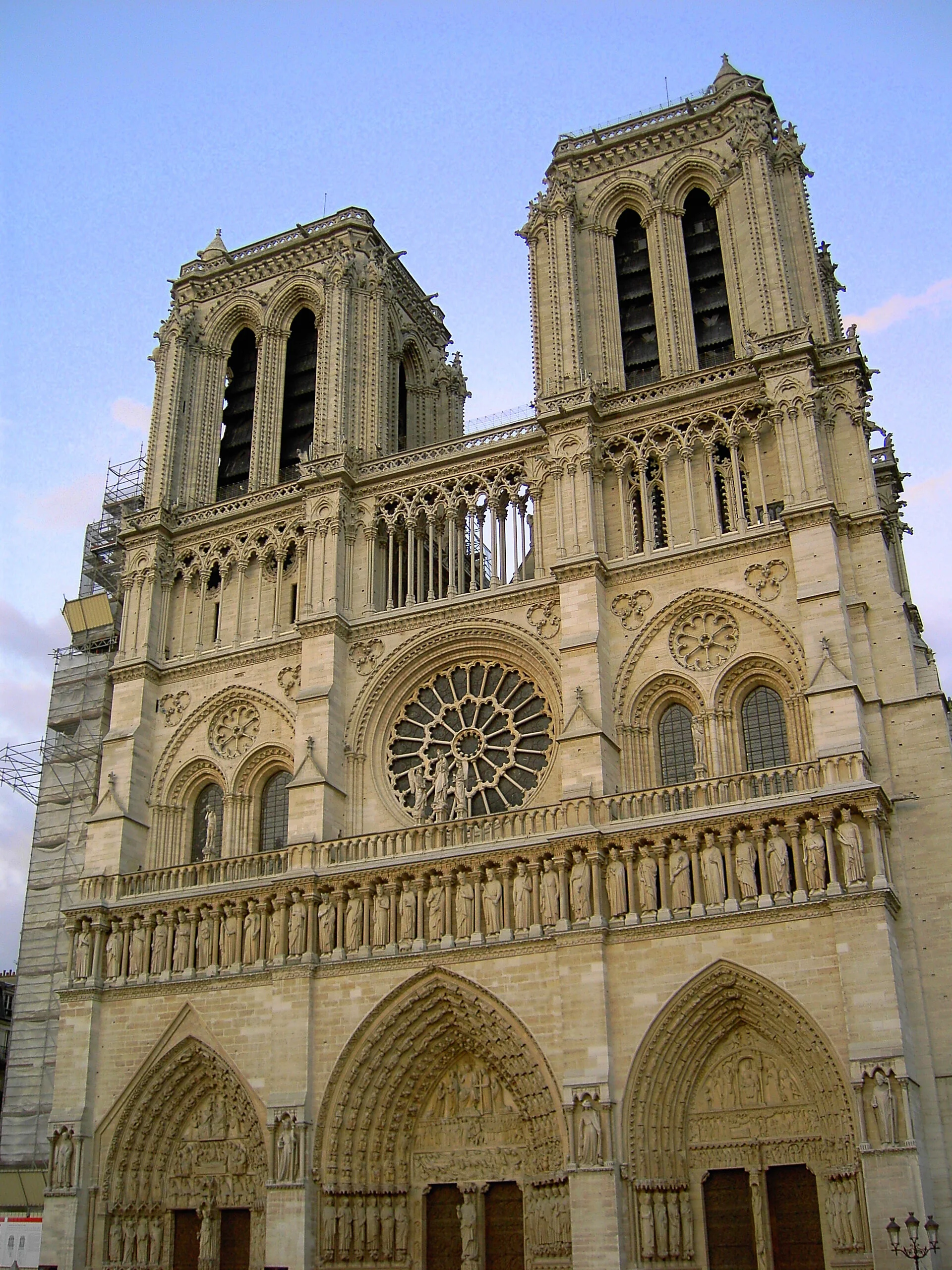 Front view of the Notre-Dame Cathedral in Paris, France, showcasing its Gothic architecture, twin towers, rose window, and ornate facade with sculptures.