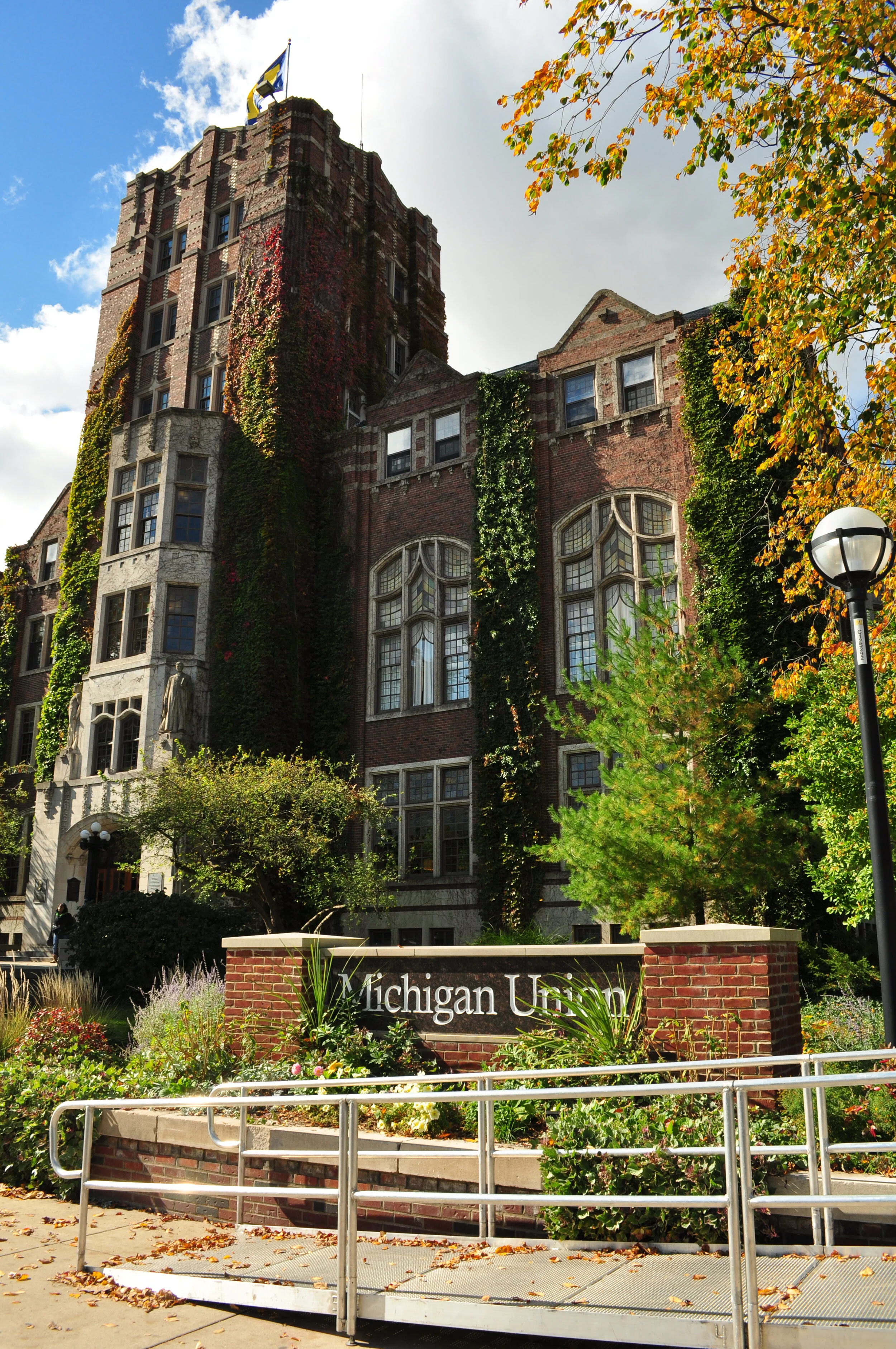 A large brick building with ivy growing on its walls, surrounded by trees, with a sign that reads 'Michigan Union' at the front entrance.
