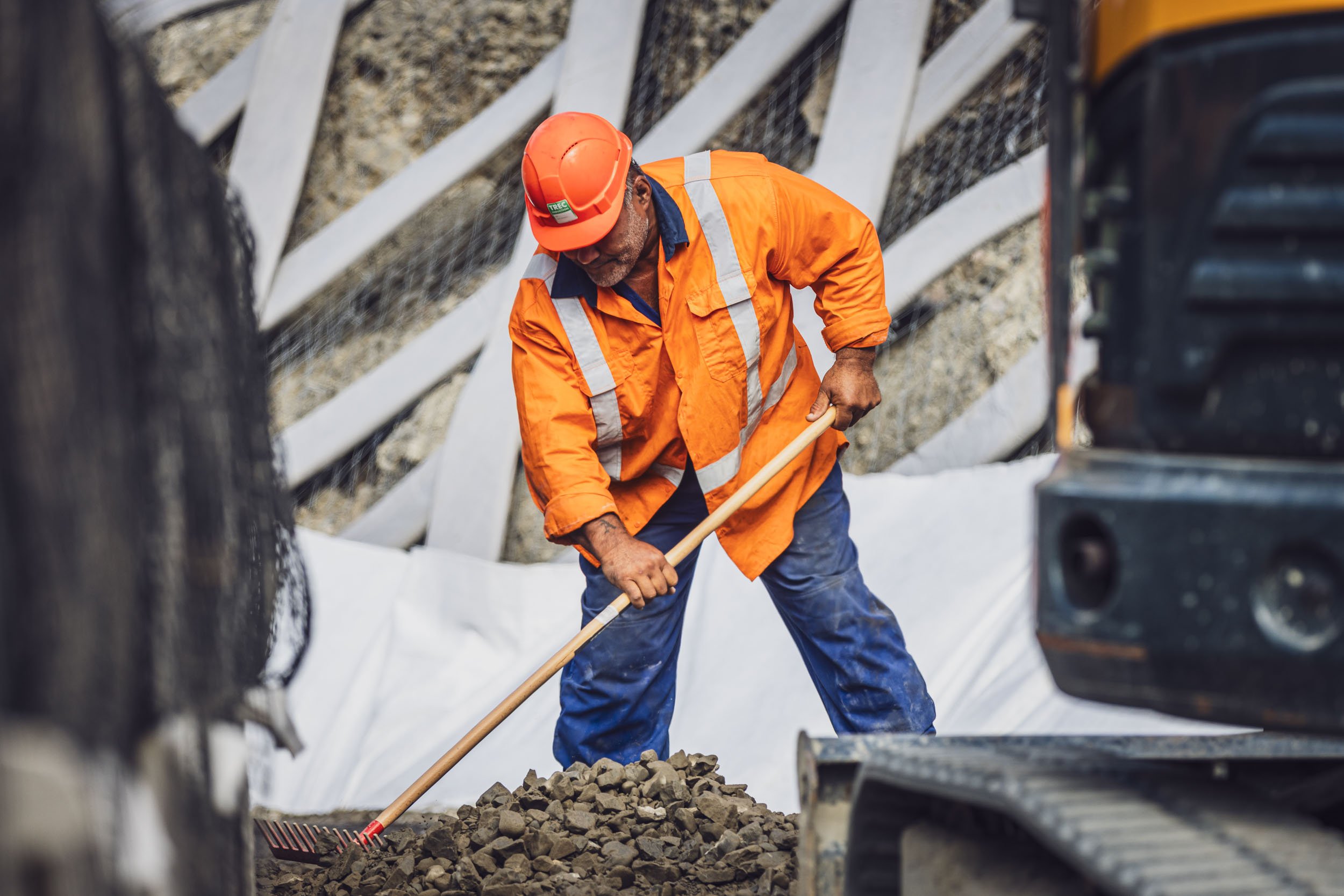 A construction worker raking stones