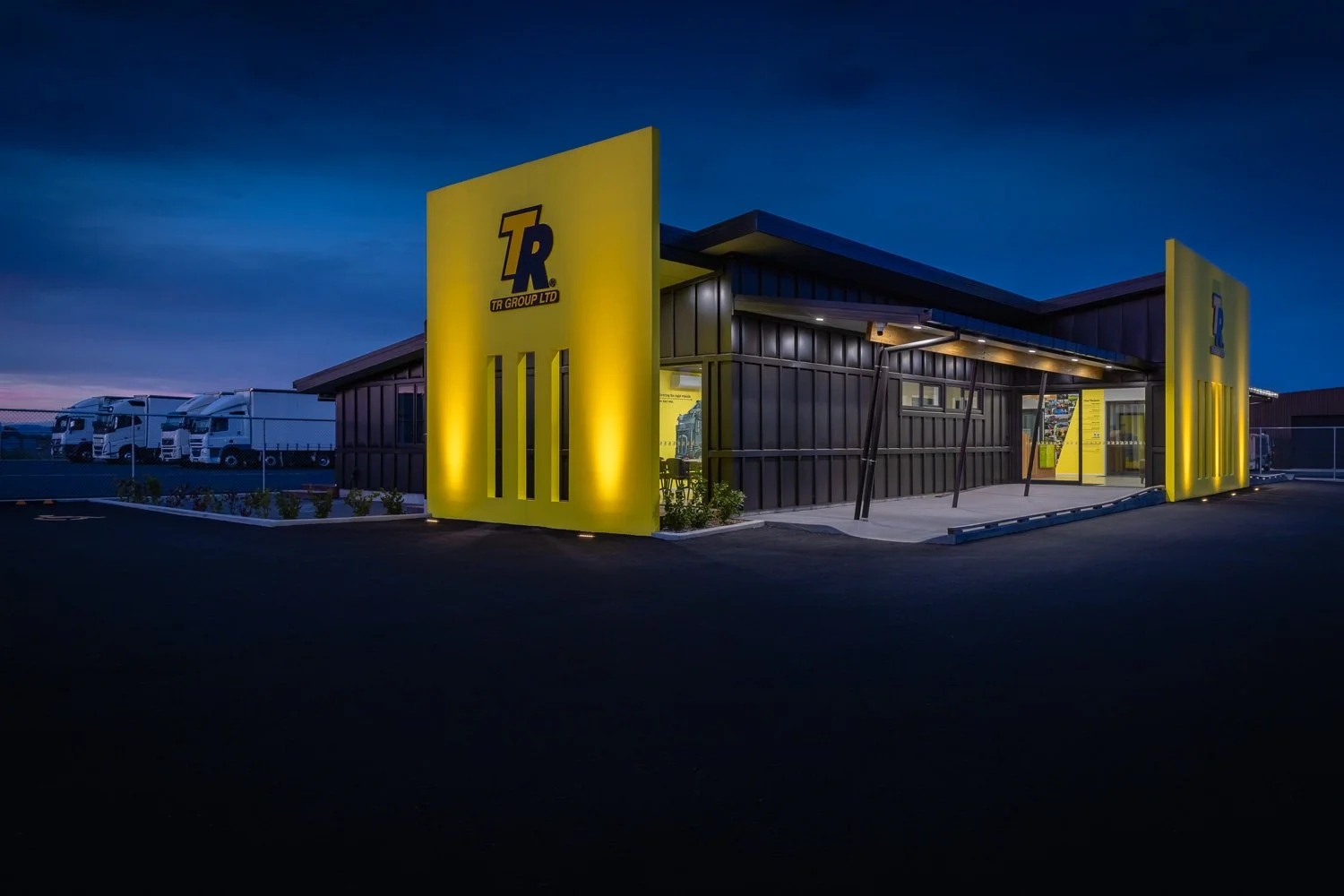 Contrasting (yellow/blue) colour image of the new TR Group building frontage in Hastings at twilight