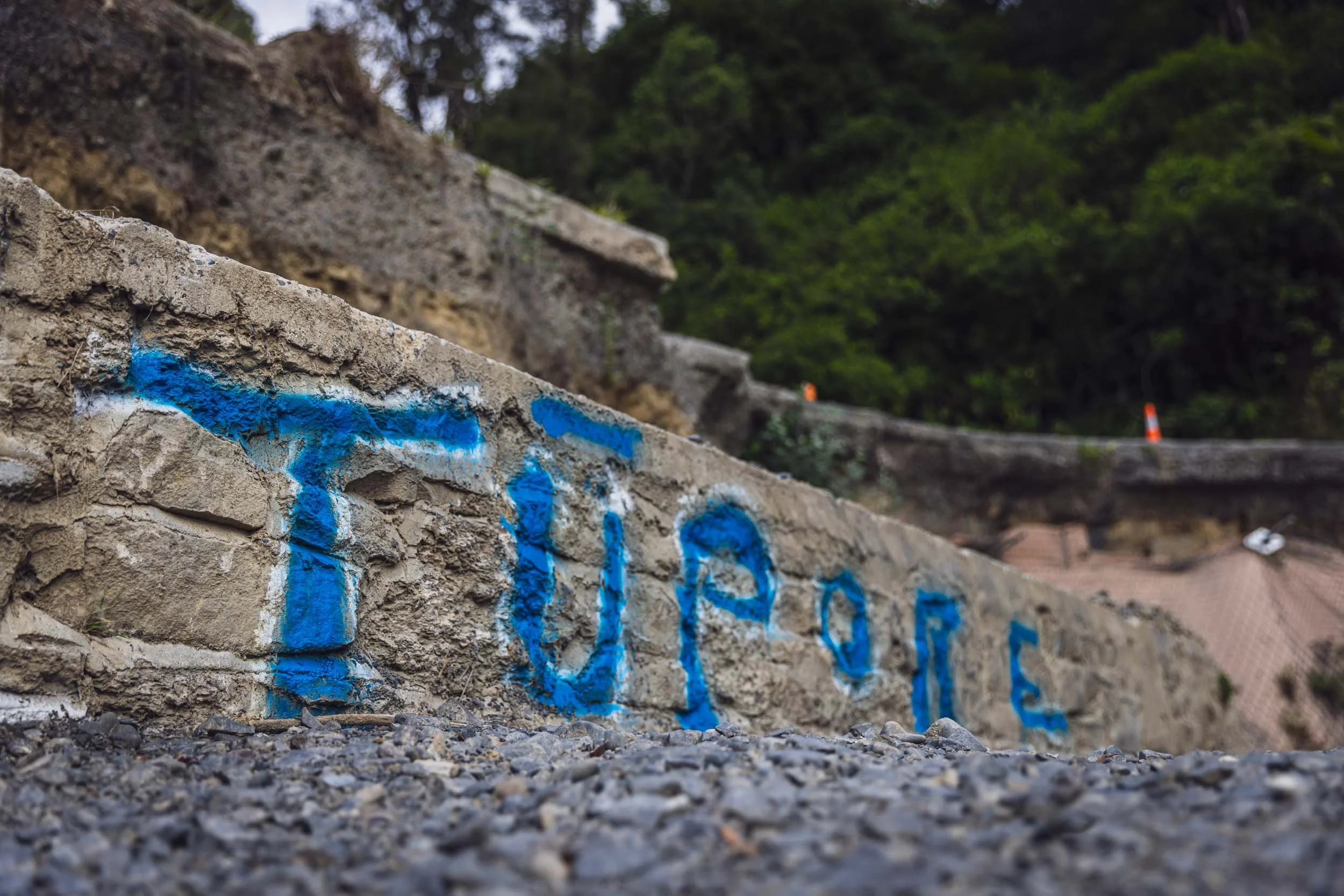 The word 'Tupore' spray painted in blue on a wall