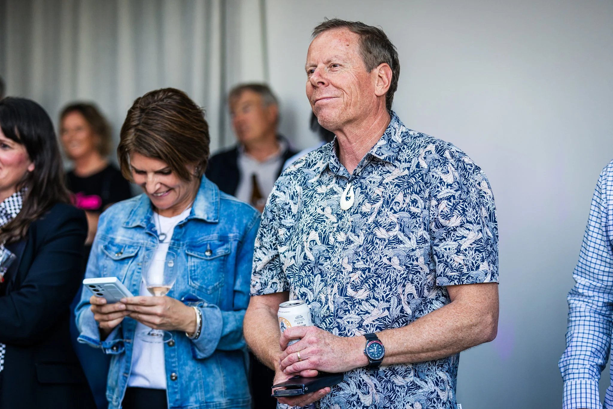 People attending a social event, enjoying drinks and smiling
