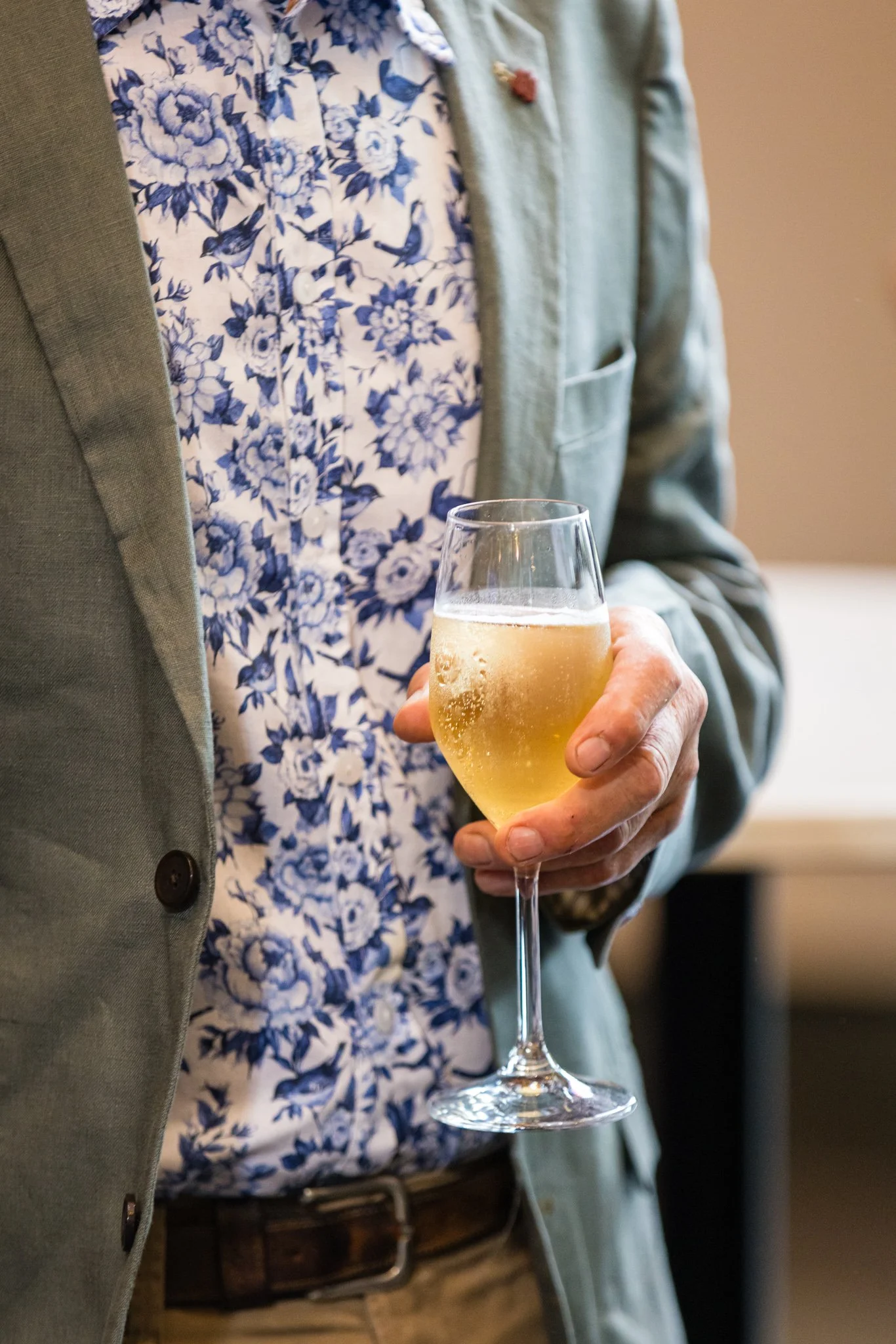 Person holding a glass of sparkling white wine or champagne