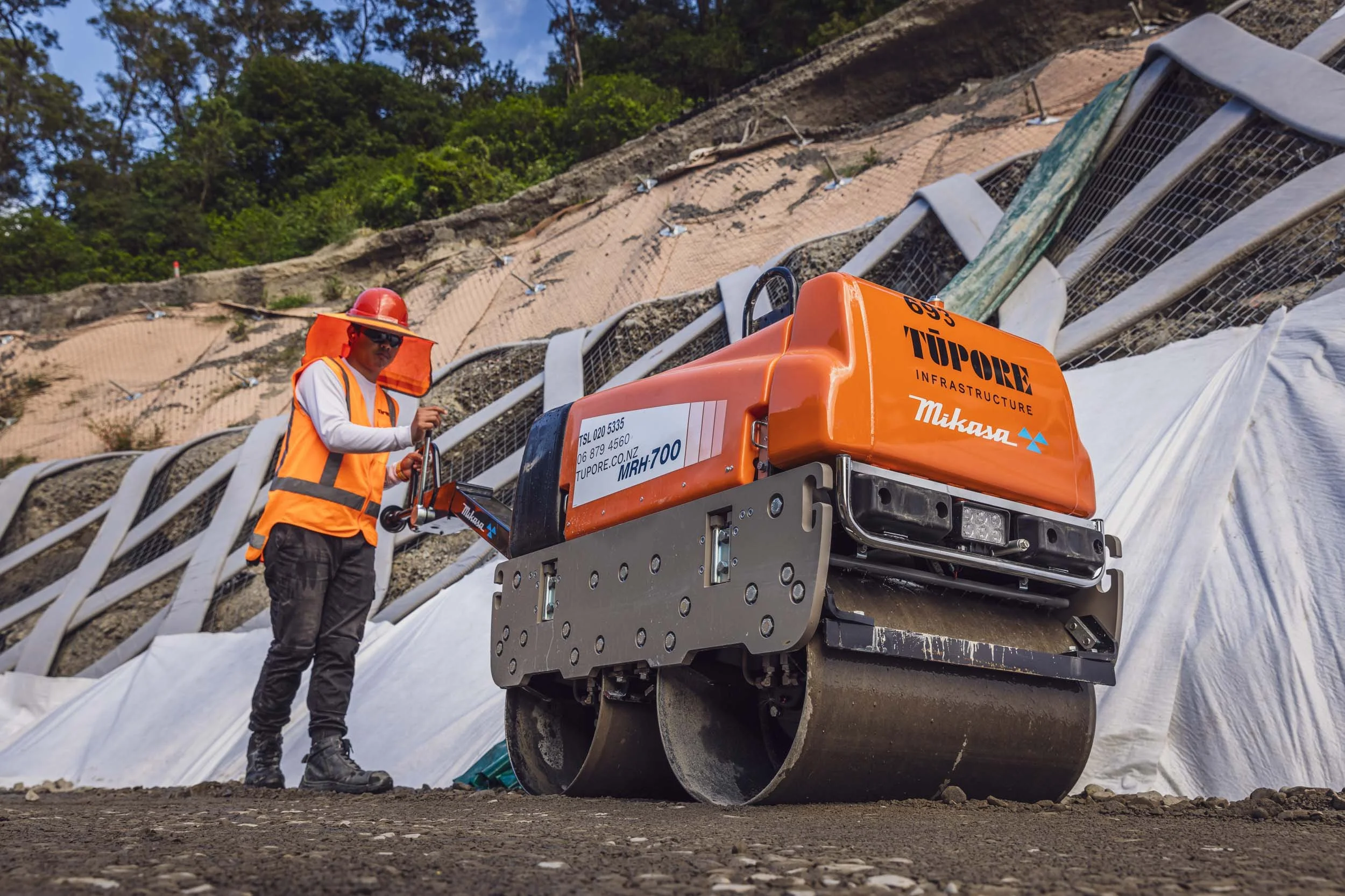 A man operating a roller compactor on a construction site in Hawke's Bay, NZ