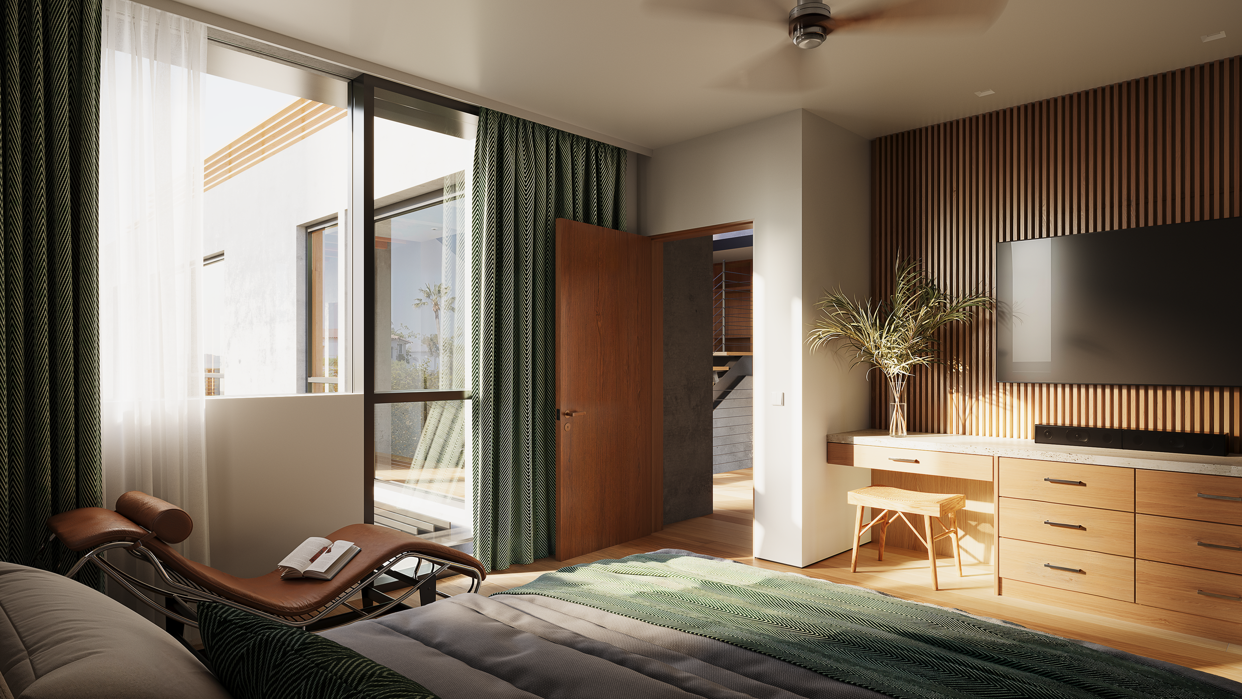 Living room with large window, green patterned curtains, wooden door open to balcony, beige countertop with a vase of greenery, wall-mounted TV, and a brown leather lounge chair with an open book on it.