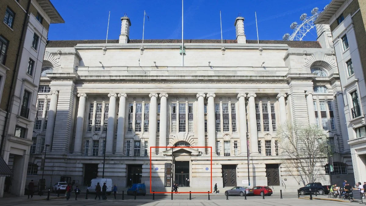 Image of the front entrance of County Hall with architectural pillars and cars on the street below