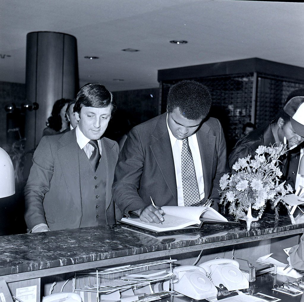 Muhammad Ali signs in at Dragonara Hotel 1979.jpg