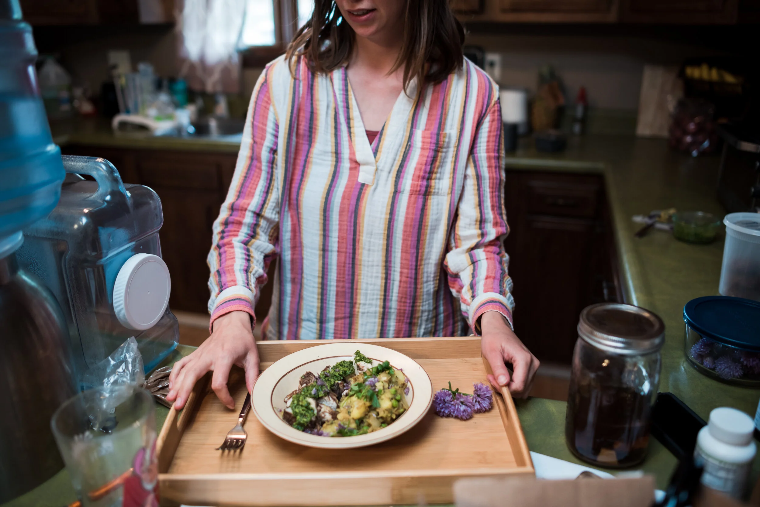Postpartum doula preparing nourishing food tray for in-home postpartum support and recovery care