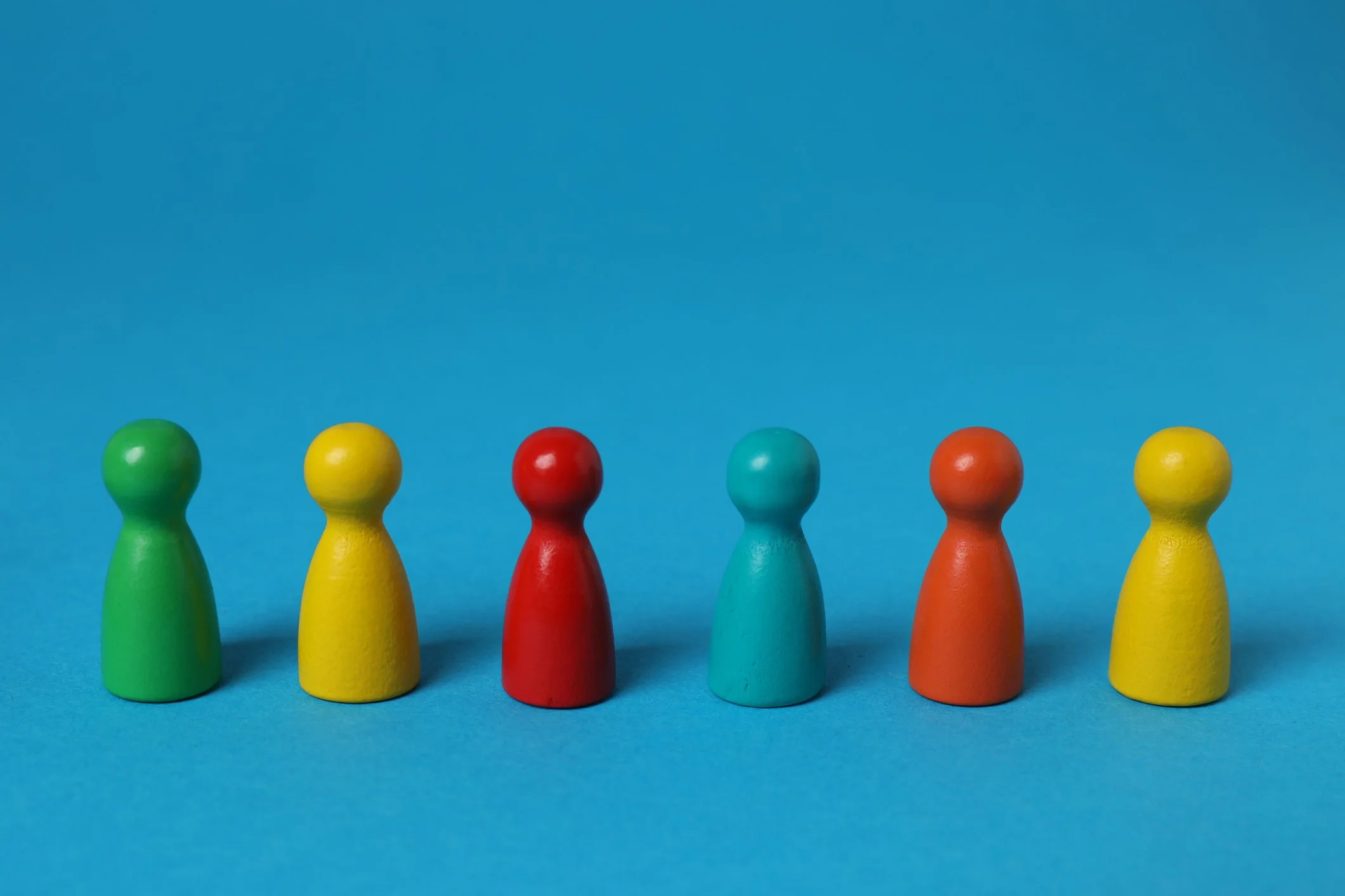 different coloured wooden figures representing a new team