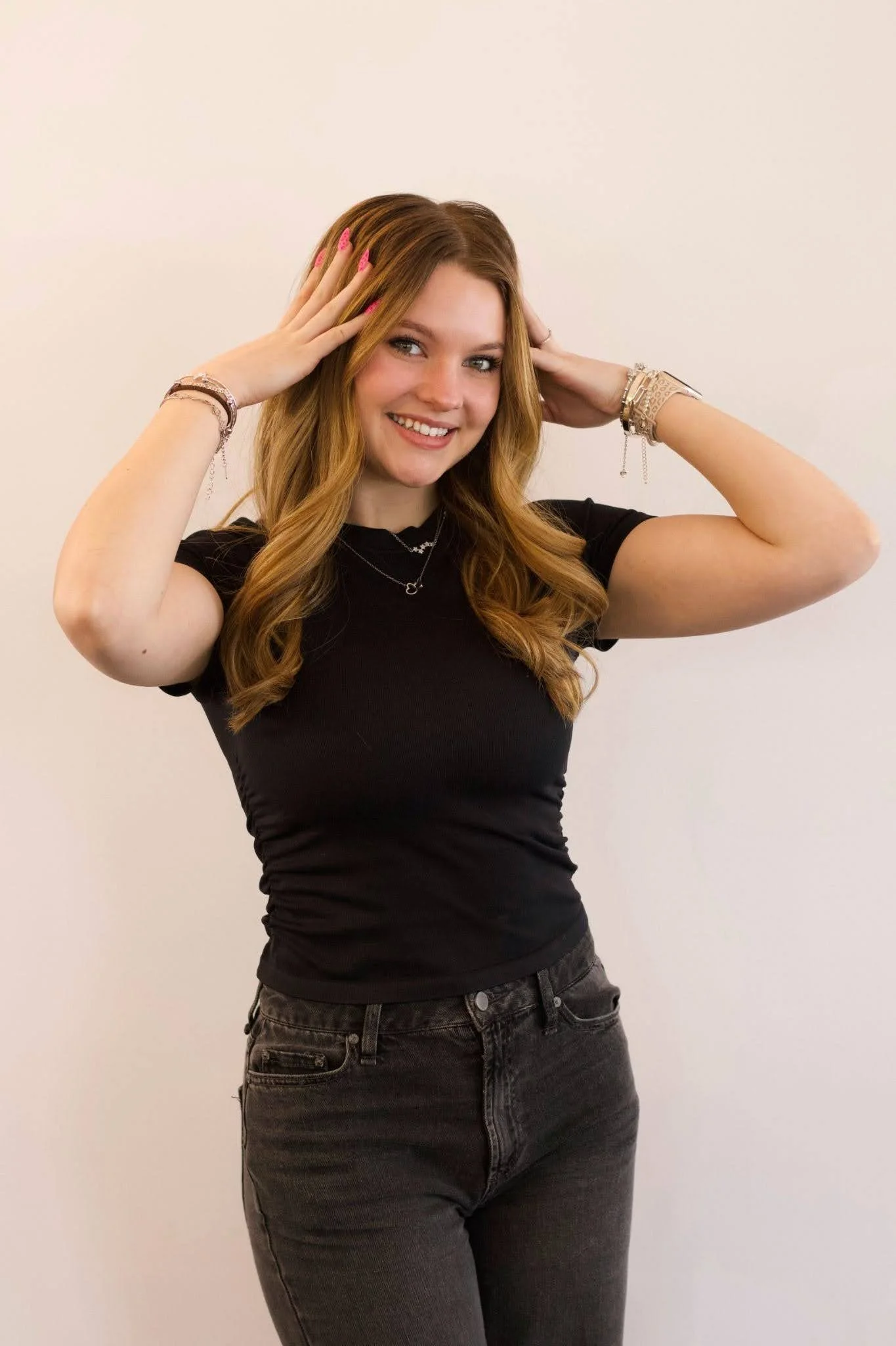 Katherine Dunfey, Teal Studio stylist specializing in haircuts and styling, smiling with long wavy brunette hair