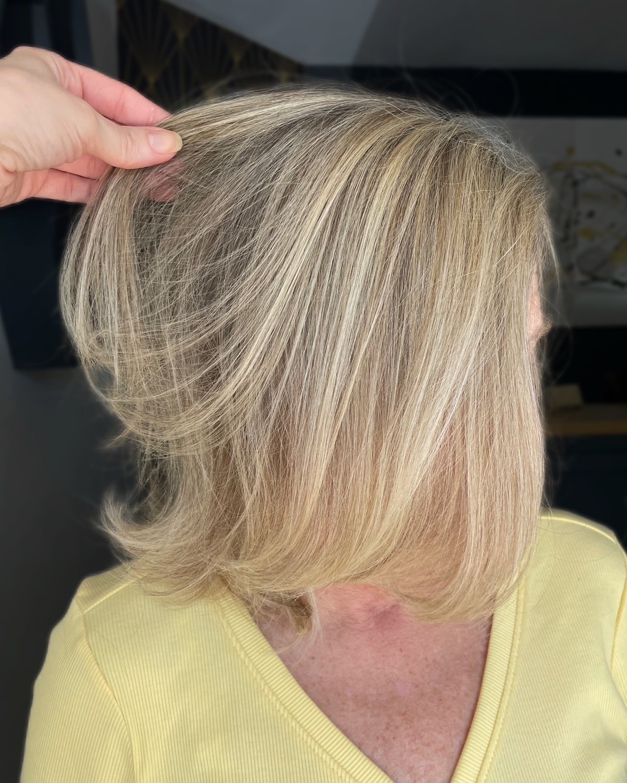 Shoulder-length blonde bob with subtle highlights, smooth layers, and softly curved ends