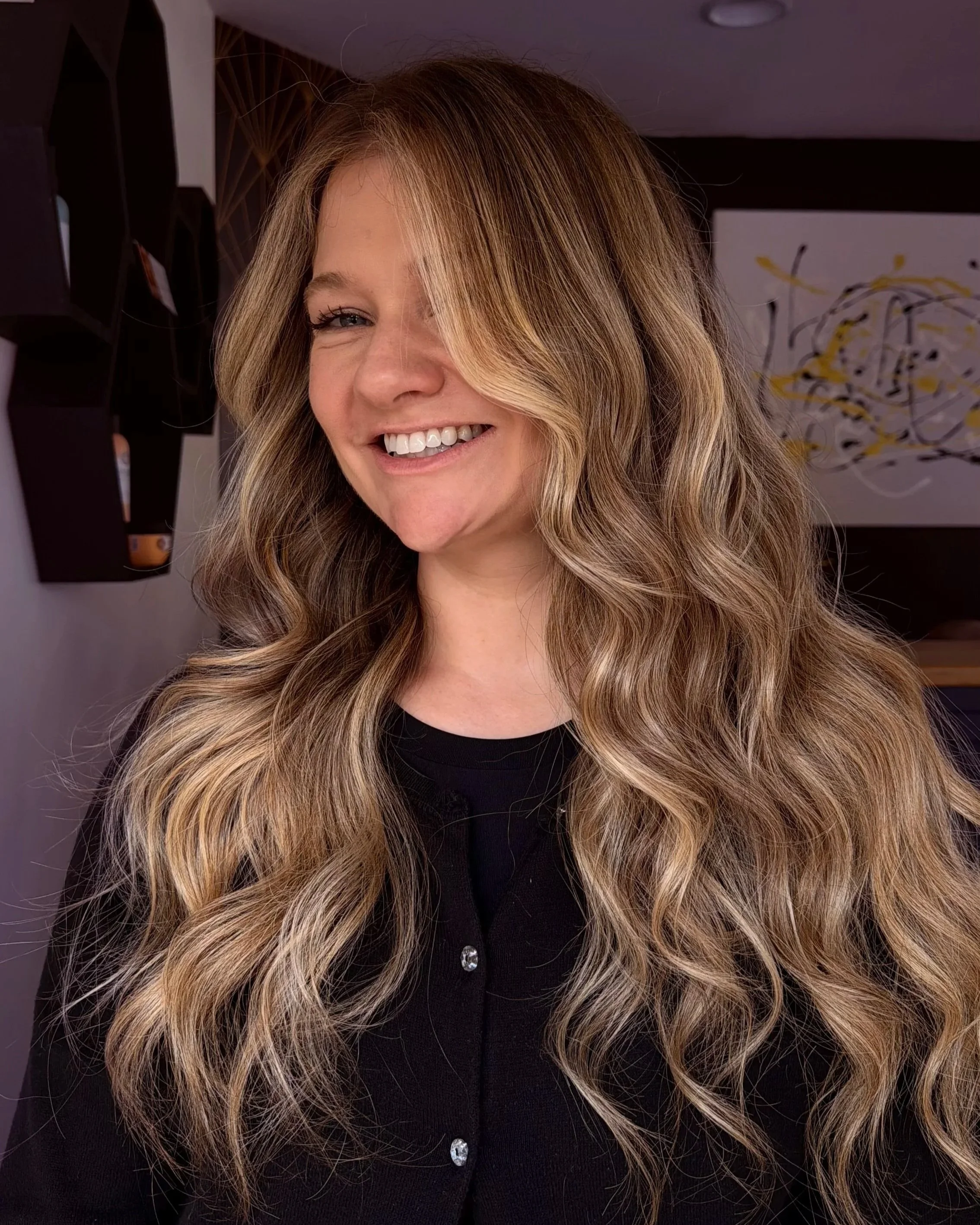 Dimensional lived-in blonde hair with soft highlights and long waves at TEAL Hair & Makeup Studio