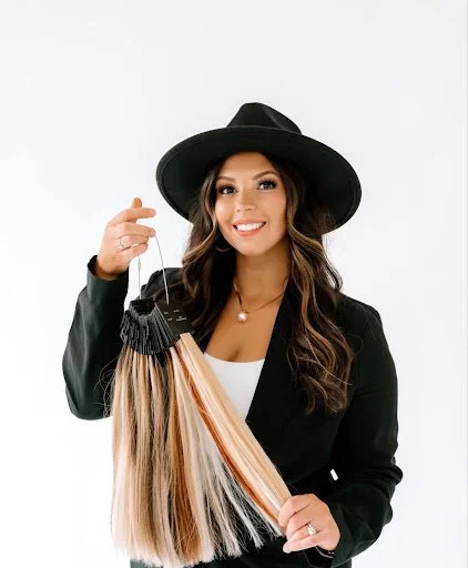 Devin Ferino, Teal Studio hair and makeup stylist and extension specialist, holding a selection of hair extensions