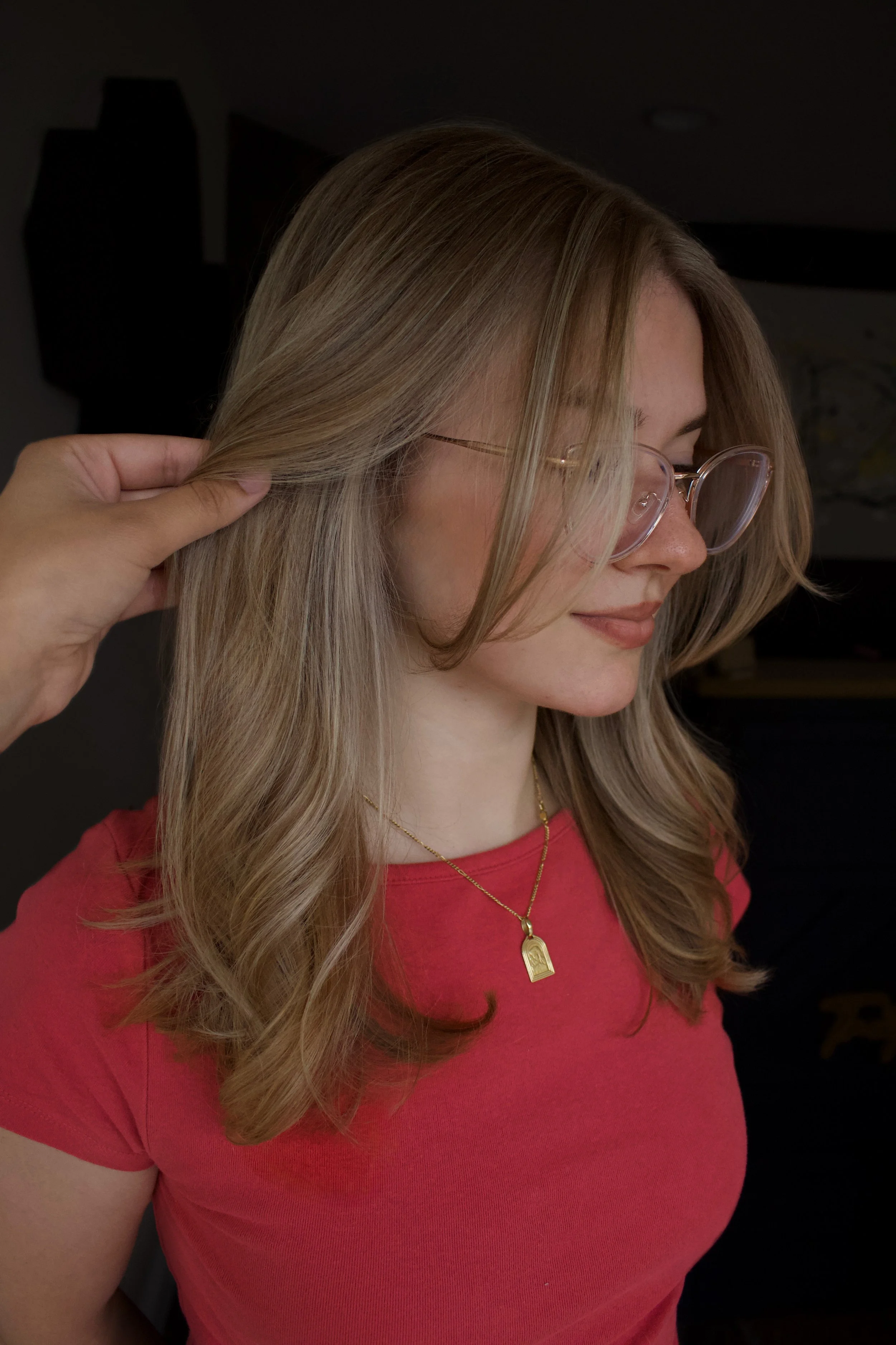 Woman with shoulder-length dimensional blonde hair featuring soft, blended highlights, darker roots, and face-framing layers, showcasing lived-in blonde hair color by Alliyah at TEAL Hair & Makeup Studio.