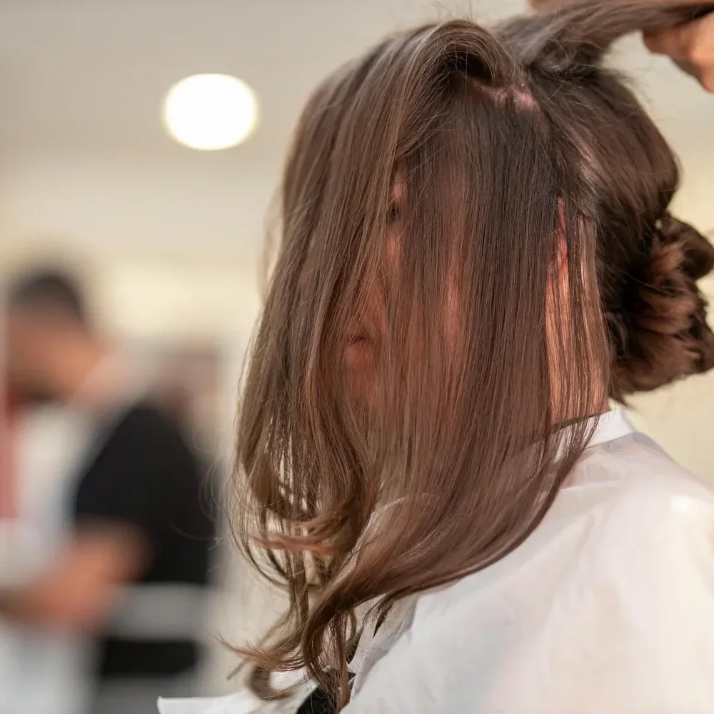 Brunette bridal hairstyle being styled with added length and volume for a wedding