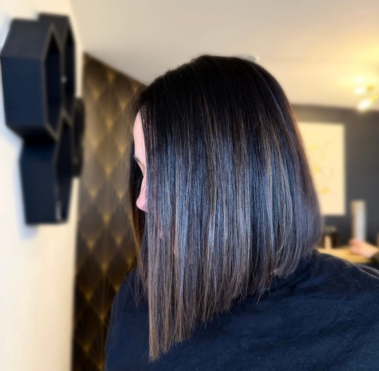 Sleek shoulder-length dark haircut with straight styling and a softly angled shape at Teal Studio