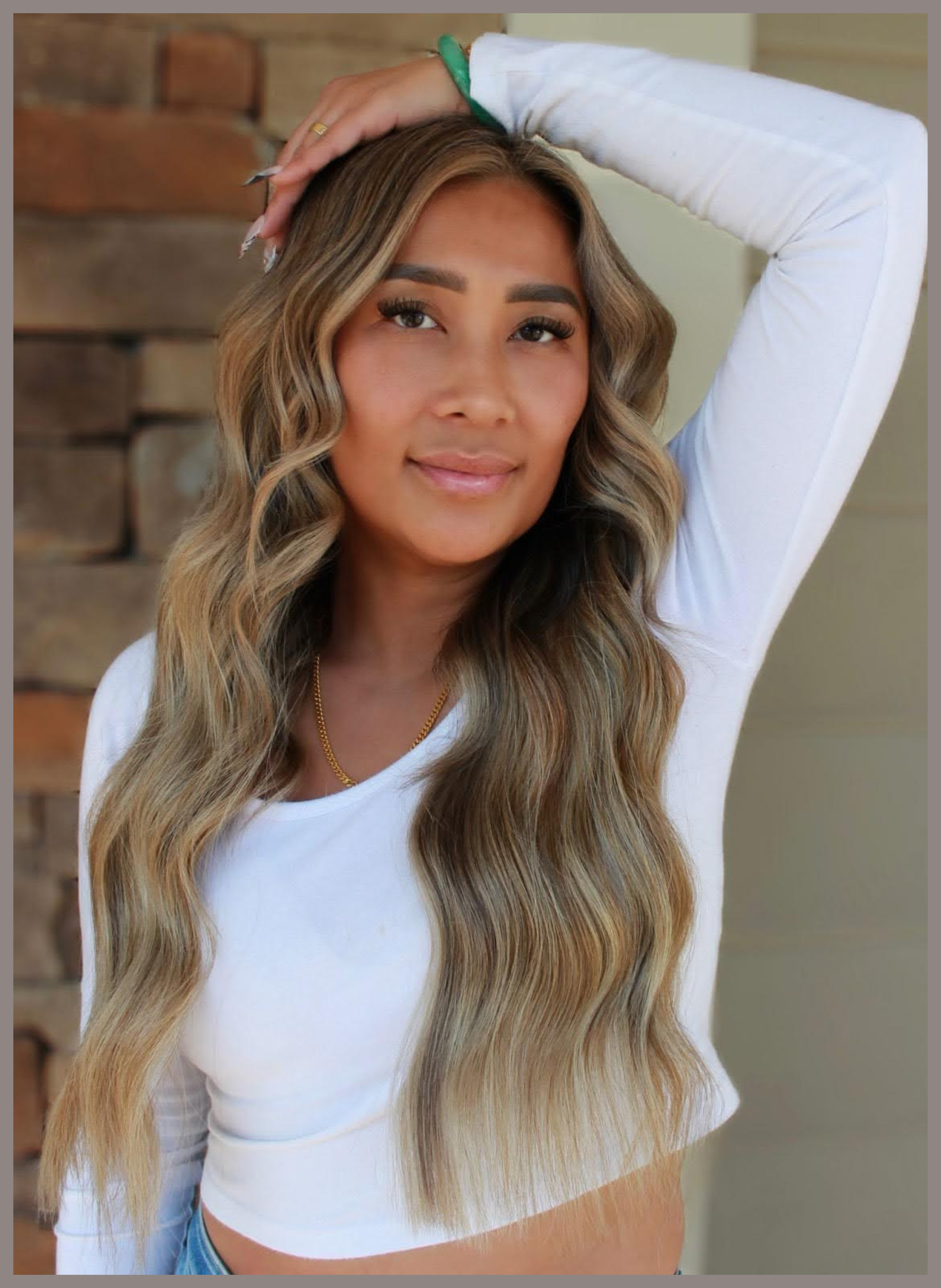 A client shows off long, voluminous hair extensions with blended bronde hair and soft teddy bear blonde highlights styled in loose waves at Teal Hair and Makeup Studio.