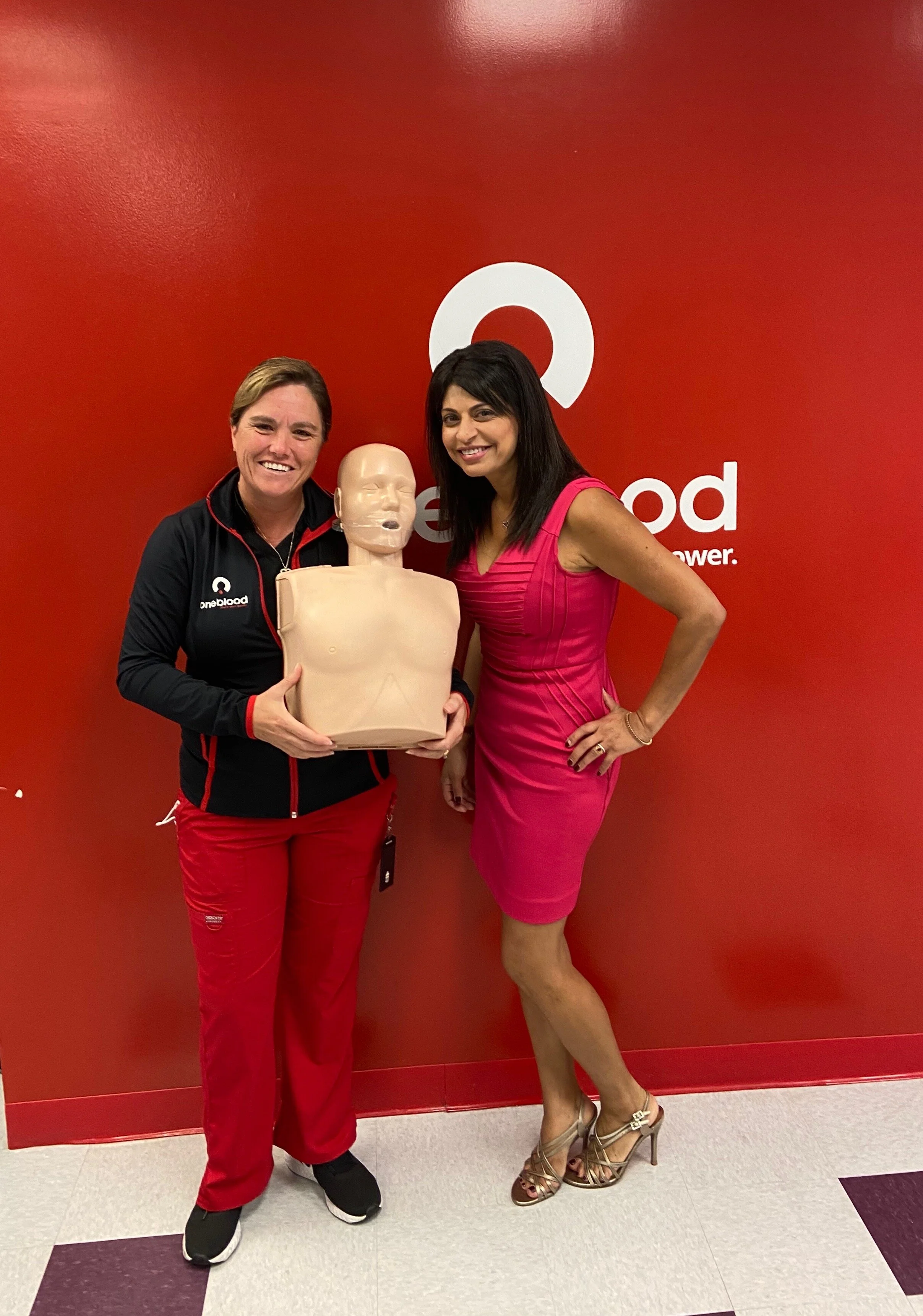 One Blood employee and Sarina Fazan holding a CPR doll.