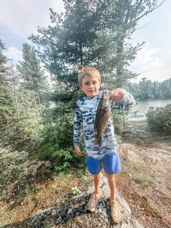 Young angler holds smallmouth bass on nightcrawler Thill bobber Eagle Claw hook August 5, 2025 in Ely MN BWCA. Summer report from Arrowhead Outdoors.