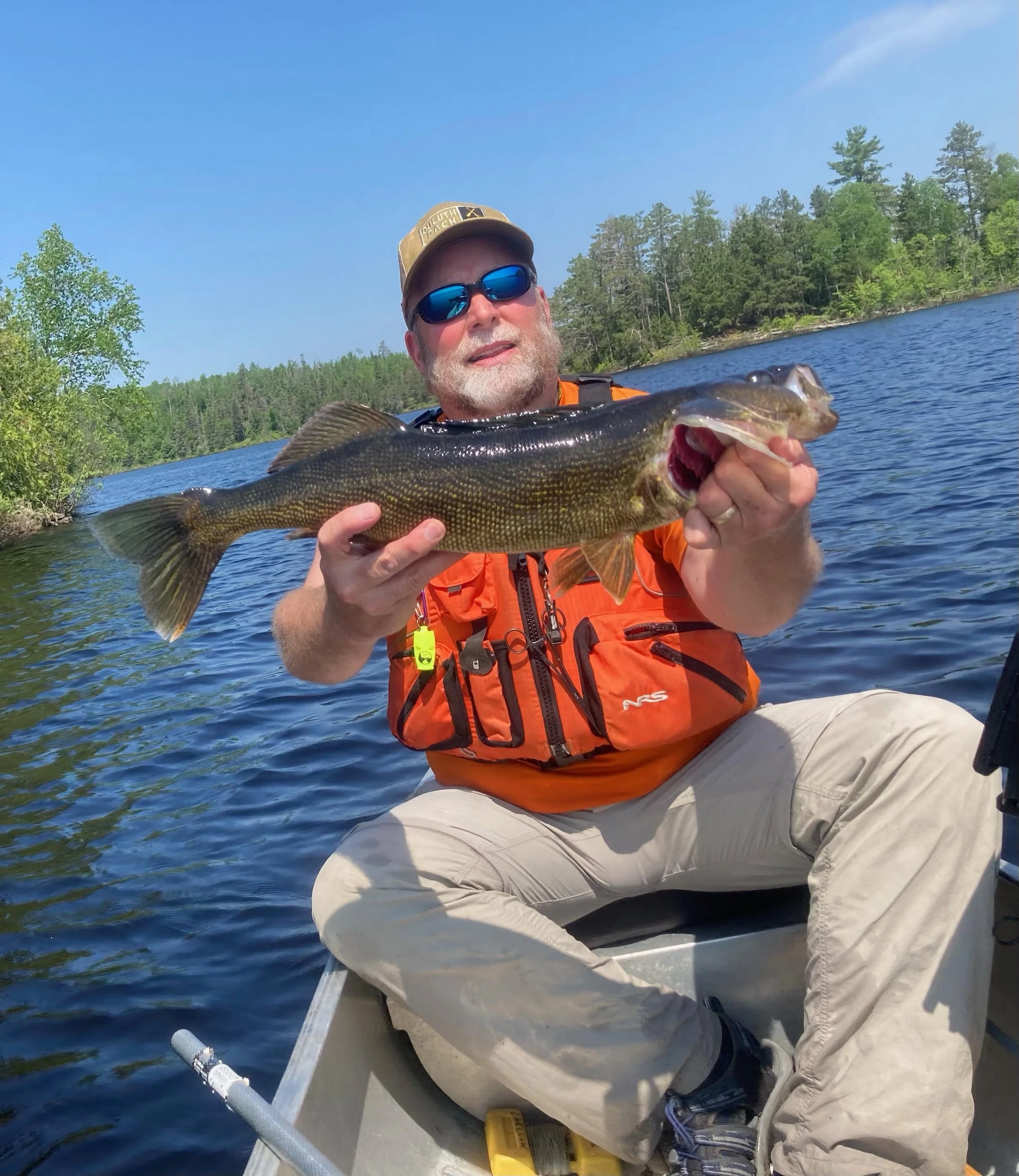 Angler with chunky smallmouth bass on BWCA boat near Ely MN, June 2023 Arrowhead Outdoors report – mid-summer bronzeback action!
