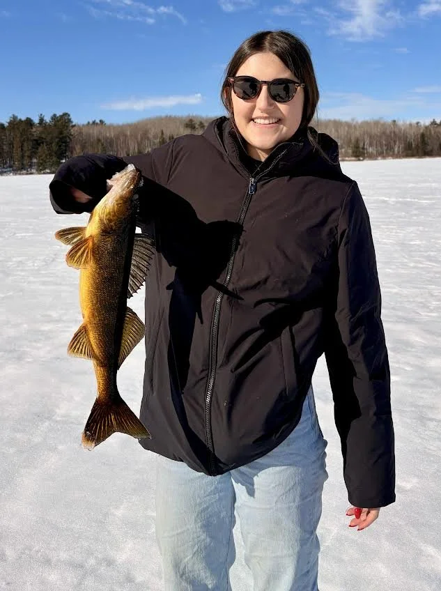 Smiling angler with trophy walleye caught ice fishing Ely MN February 17 2026 – beautiful golden walleye held high on snowy BWCA ice at Arrowhead Outdoors