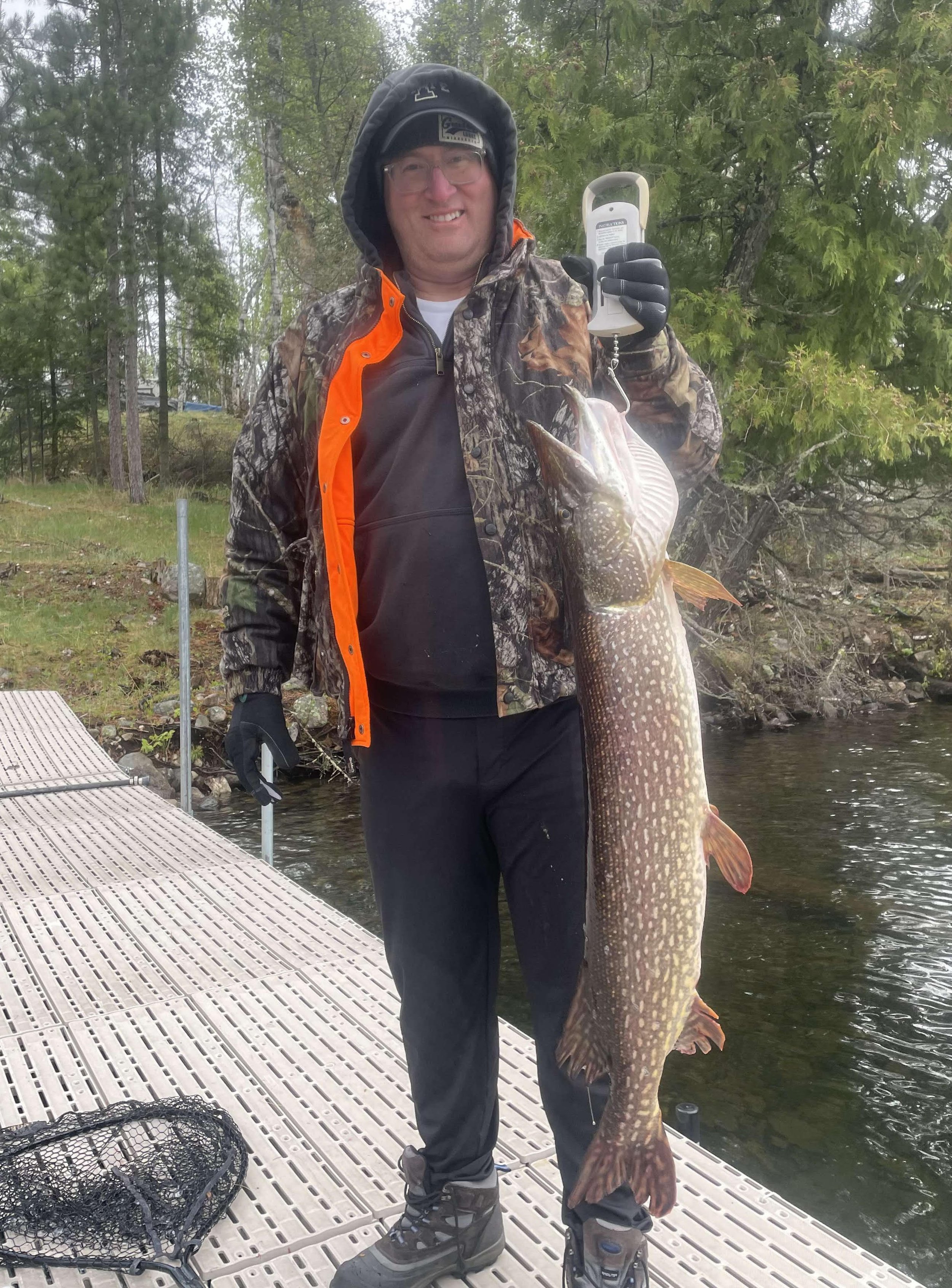 Angler holds giant northern pike caught off dock on frozen herring May 20, 2025 in Ely MN BWCA. Early season report from Arrowhead Outdoors.
