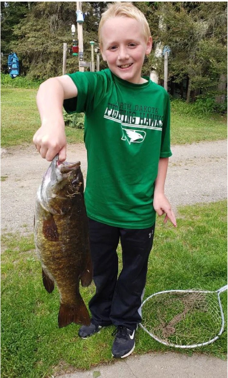 BWCA smallmouth bass caught by kid Ely MN - Young angler trophy smallie hold Boundary Waters Arrowhead Outdoors report