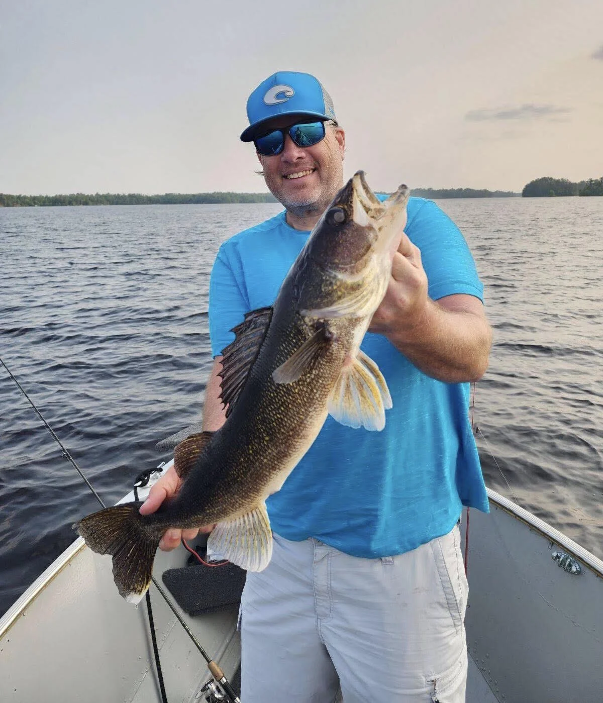 Ely MN BWCA walleye catch in Arrowhead Outdoors fishing report July 18 2023 – angler holding golden walleye on boat sunny lake
