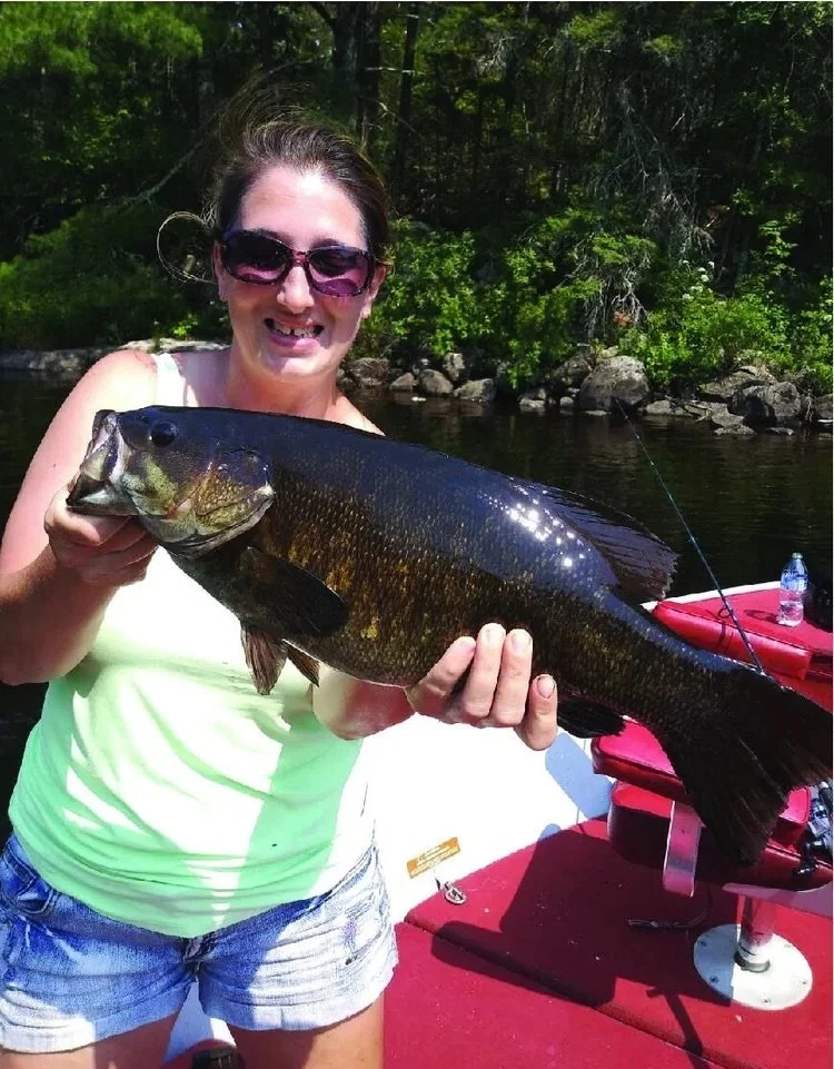 Ely MN BWCA smallmouth bass open water catch June 16 2021, young angler holding bronze smallie at sunset on boat, Arrowhead Outdoors report
