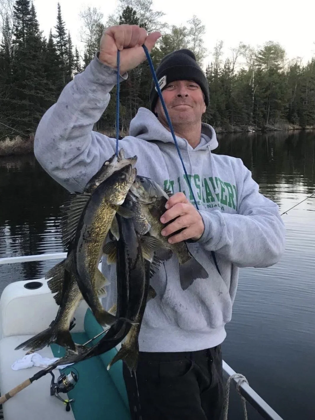 Ely MN BWCA walleye and smallmouth catch in Arrowhead Outdoors fishing report May 23 2023 – angler holding stringer haul on boat in Northwoods