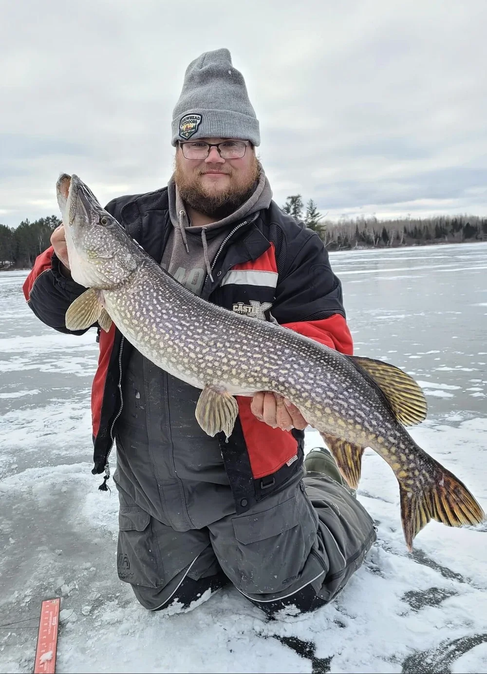 Ely MN BWCA northern pike ice fishing catch Dec 1 2021, angler holding big toothy pike on fresh ice, Arrowhead Outdoors report