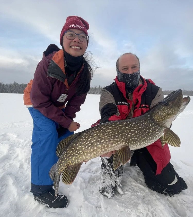 Ely MN BWCA northern pike ice fishing couple catch Feb 16 2021, partners holding big toothy pike on snowy frozen lake, Arrowhead Outdoors report