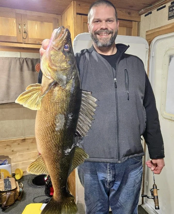 Angler holds trophy walleye inside heated ice shack January 29, 2025 in Ely MN BWCA. Winter fishing report from Arrowhead Outdoors.