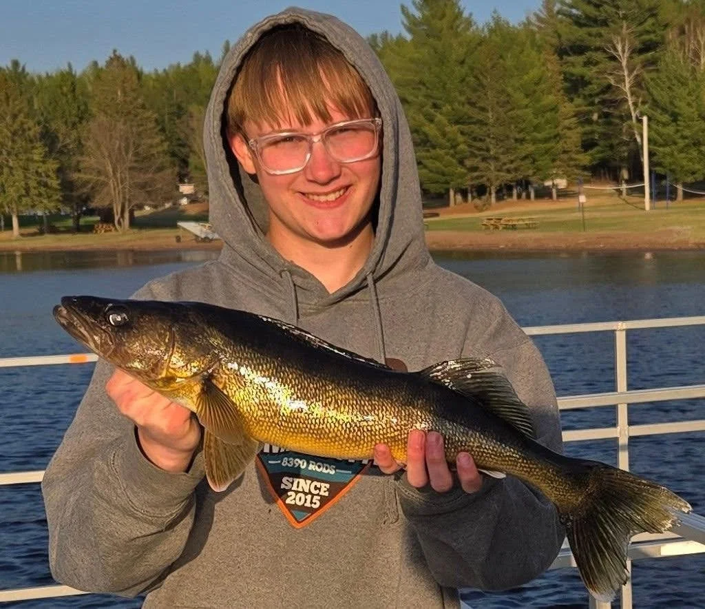 Young angler holds walleye caught on Thill bobber with leech off dock June 24, 2025 in Ely MN BWCA. Summer report from Arrowhead Outdoors.