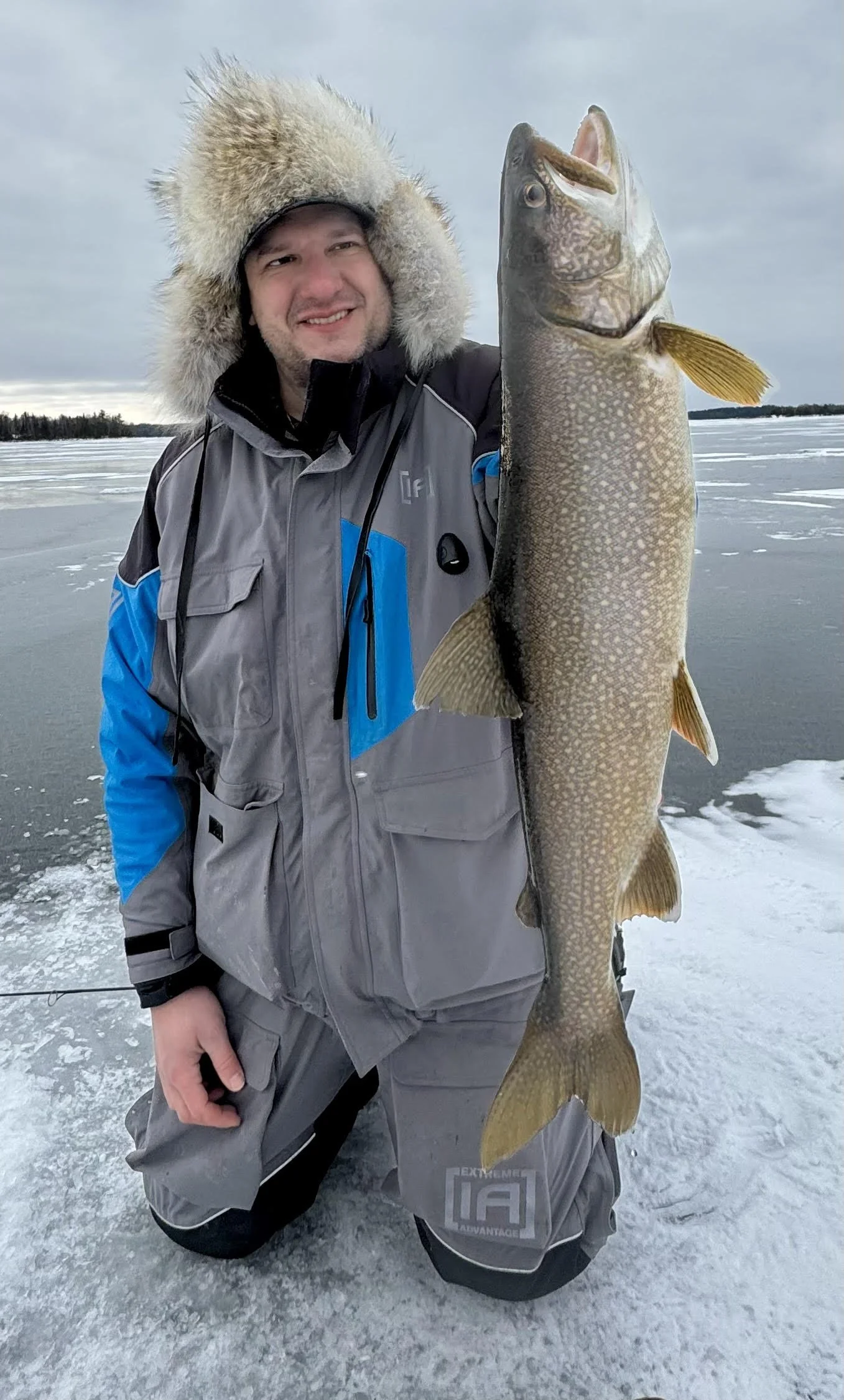 Trophy lake trout held by angler on ice after jigging Laker Tackle Tube Jig January 8, 2025 in Ely MN BWCA. Winter fishing report from Arrowhead Outdoors.