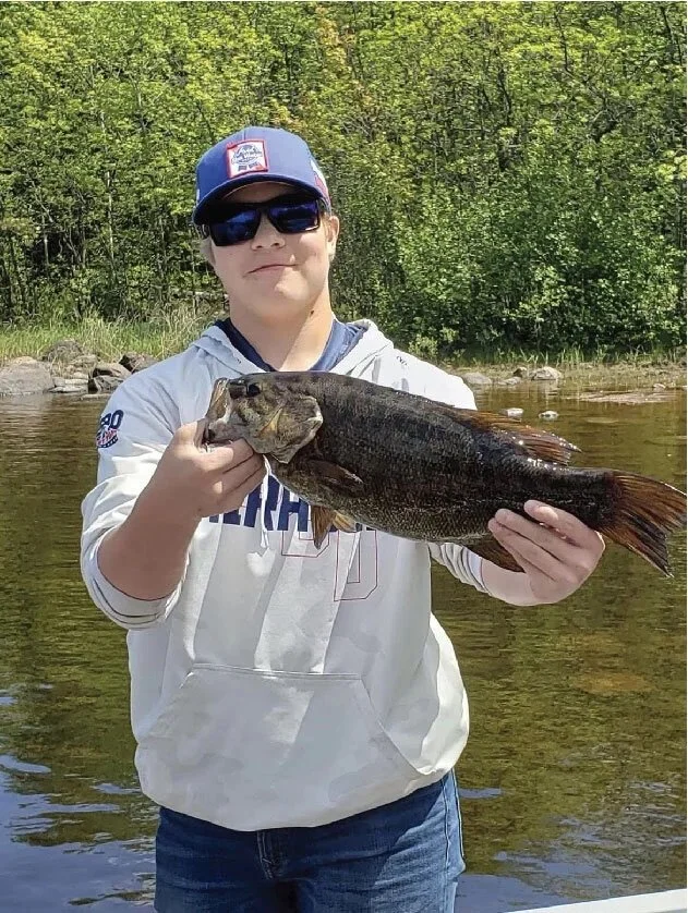 Ely MN BWCA kid smallmouth bass open water catch May 25 2021, young angler holding bronze smallie on foggy boat, Arrowhead Outdoors report